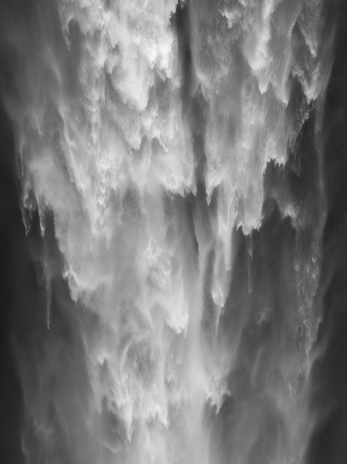 Black and white image of a waterfall cascading down a rock face.