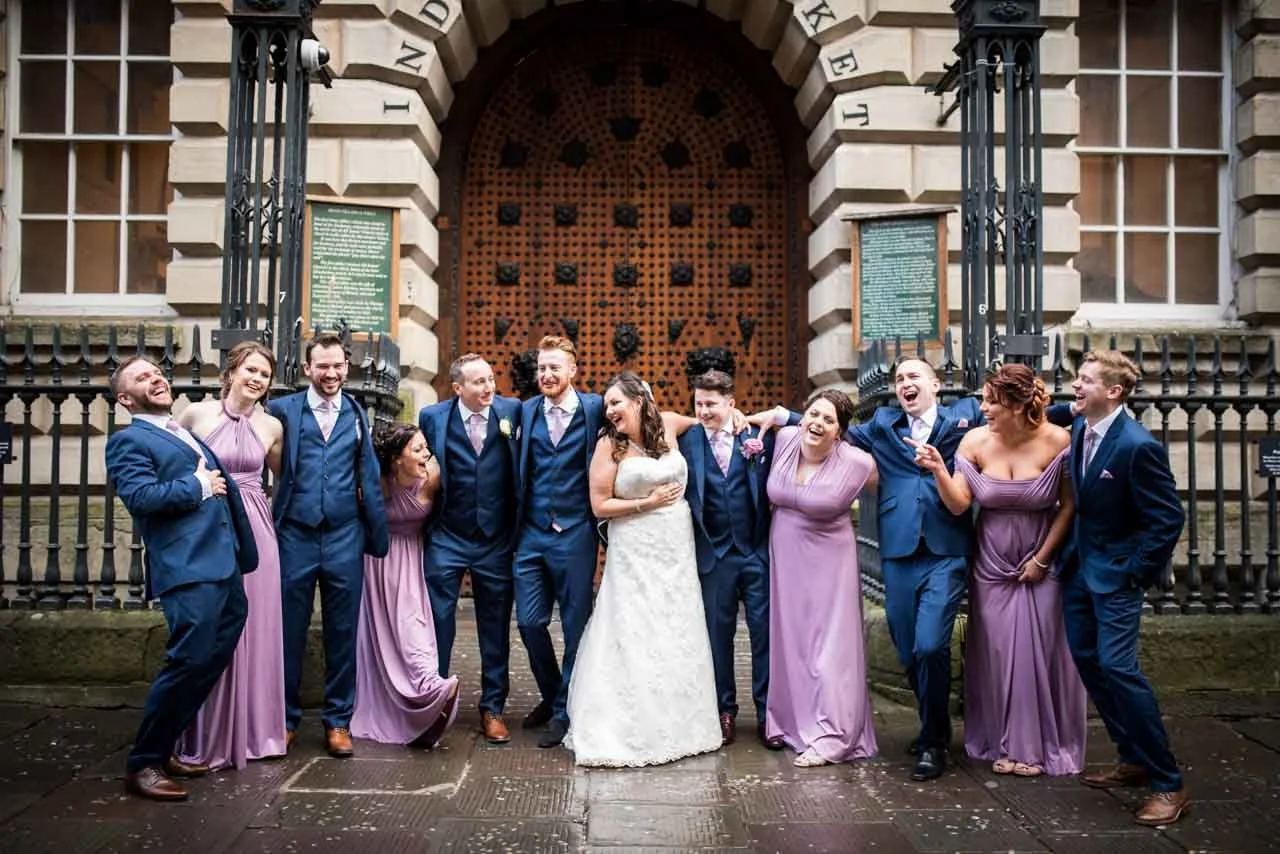 bridesmaids and groomsmen posing for group photo on Corn Street in Bristol
