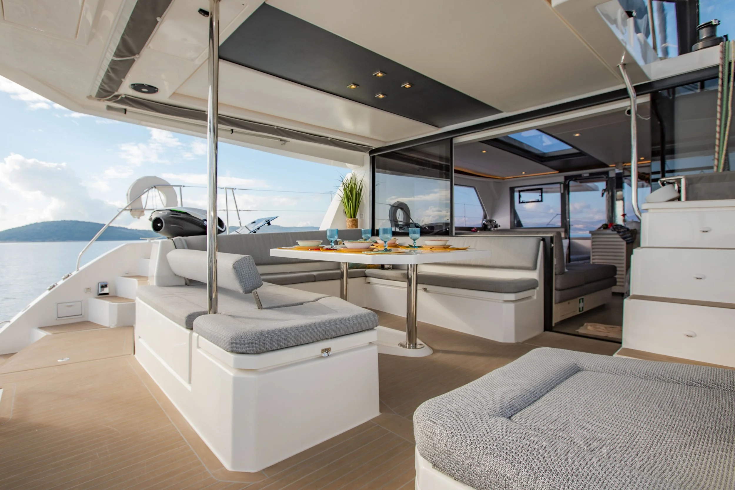 Interior of a yacht with a dining area, seating, and ocean view