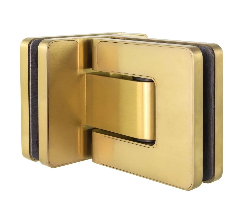 A gold-colored hydraulic clamp or holding device with multiple components stacked together