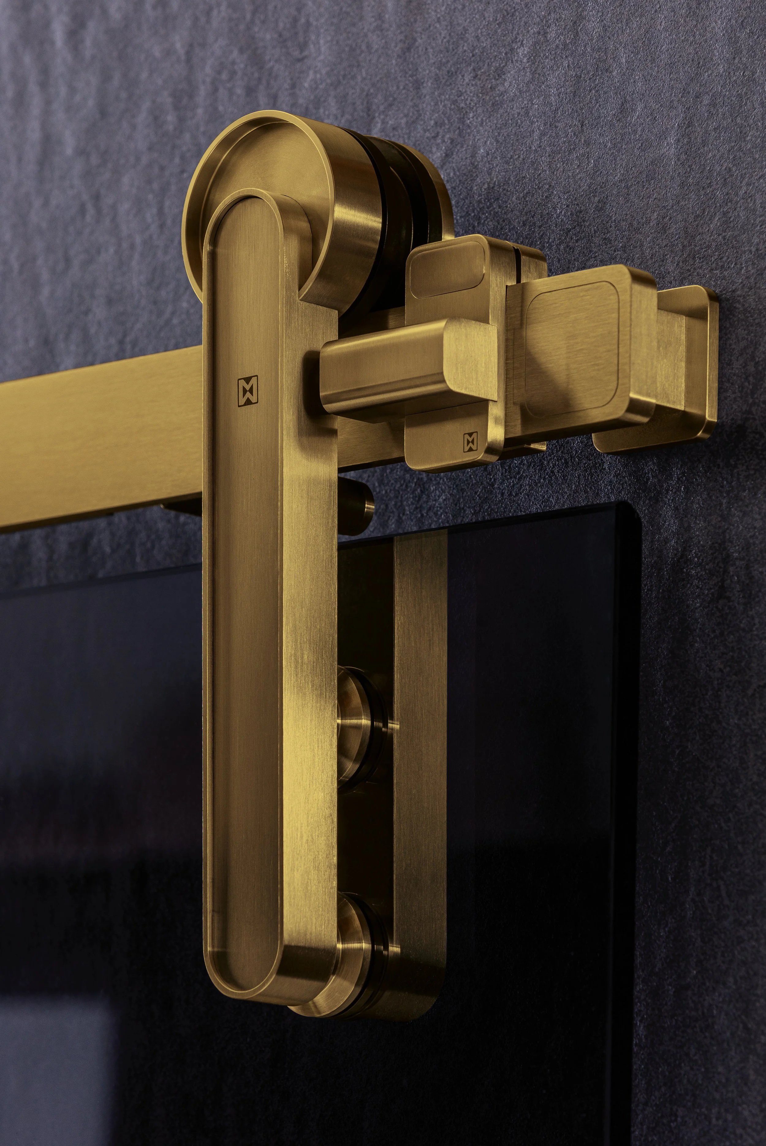 Close-up of a metallic gold-toned structure with several interconnected parts on a dark, textured surface.