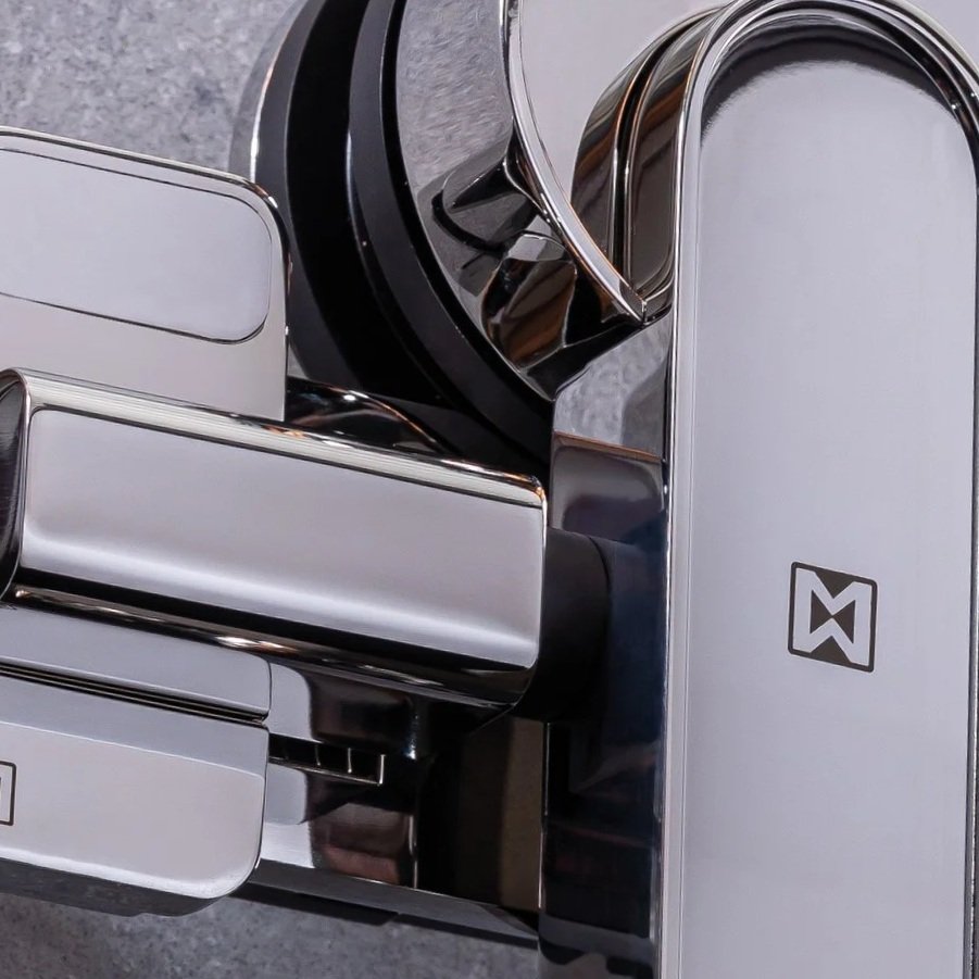 A modern, sleek, silver and black electronic device with a minimalist design, featuring sharp edges and a reflective surface.