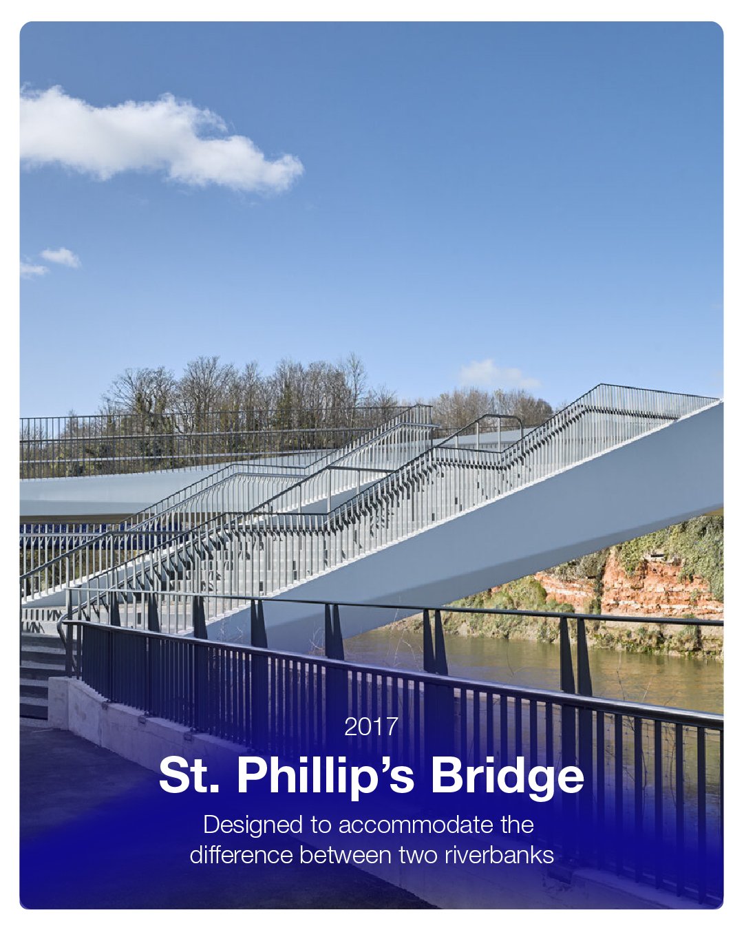 A modern white pedestrian bridge crossing over a river with railings, trees in the background, and a blue sky with clouds, labeled 'St. Philip's Bridge 2017, designed to accommodate the difference between two riverbanks'.