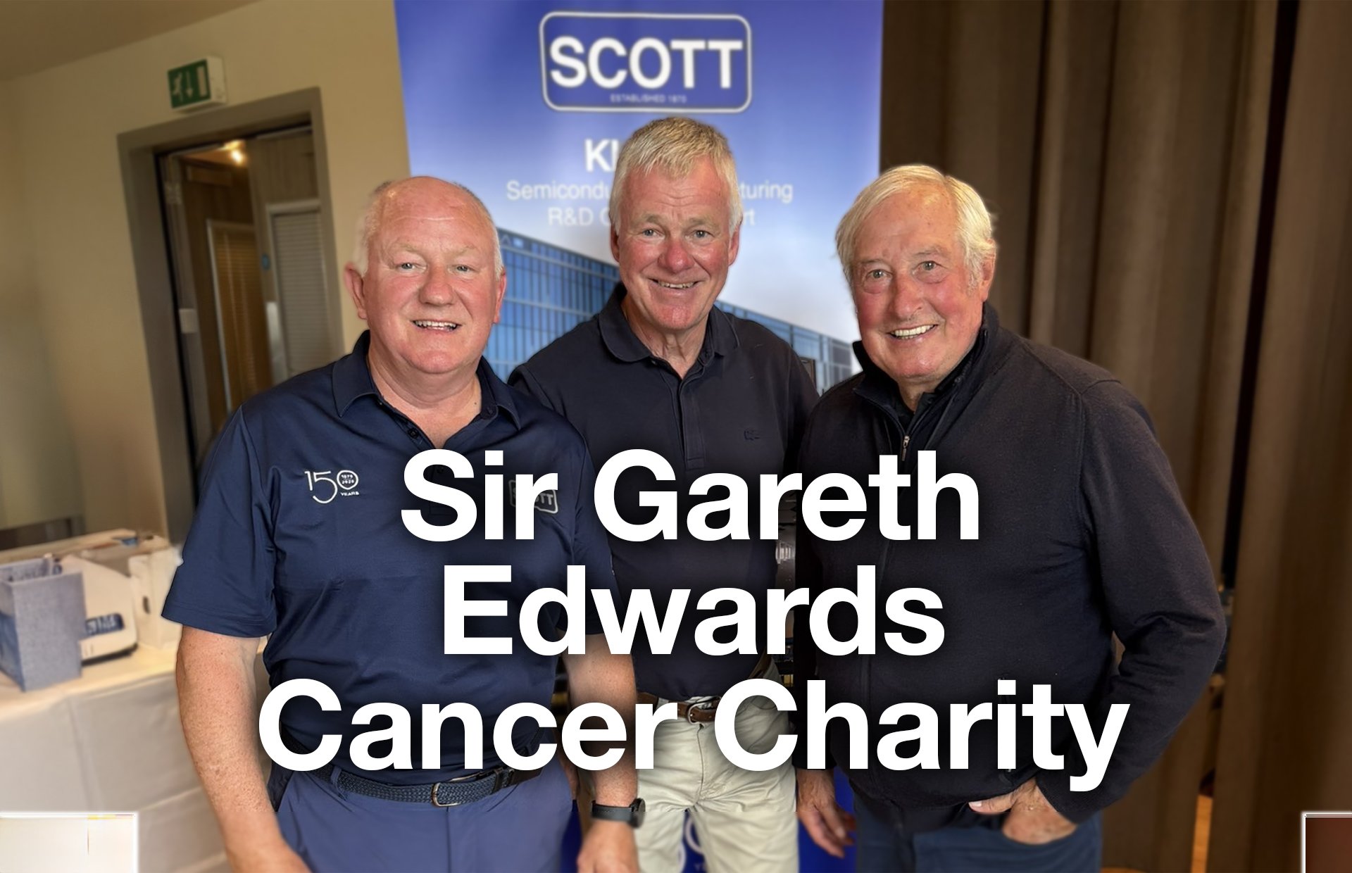 Three men standing together smiling at an event with a backdrop displaying the Scott company logo. The text overlay reads: 'Sir Gareth Edwards Cancer Charity'.