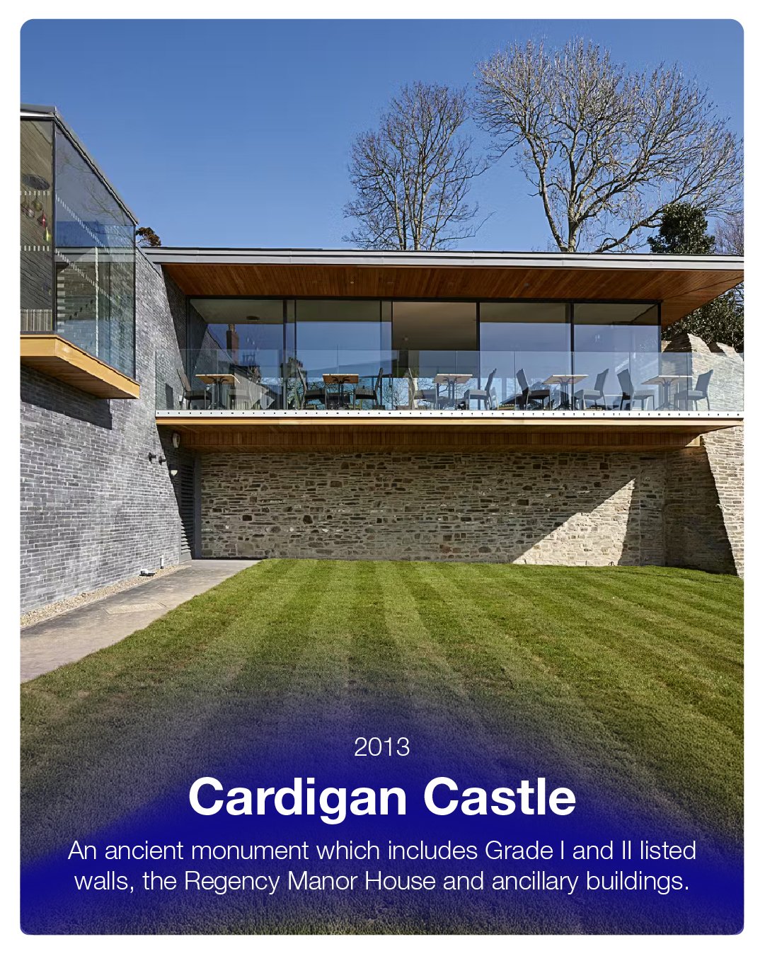 Modern building with large glass windows, stone walls, wooden overhangs, and a manicured lawn, identified as Cardigan Castle from 2013, featuring historic Grade I and II listed walls and buildings.