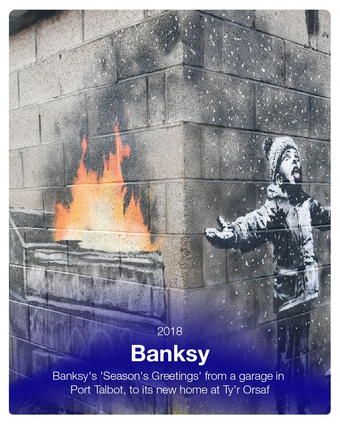 Street art mural of a young child wearing a winter hat, extending their hand towards a campfire painted on a brick wall, with snow falling around. Text overlay mentions Banksy's 2018 'Season's Greetings' graffiti from a garage in Port Talbot to a new