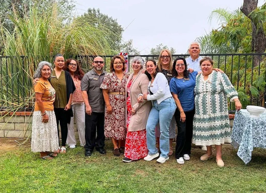 Grupo de personas sonriendo en un jardín, posando para una foto.