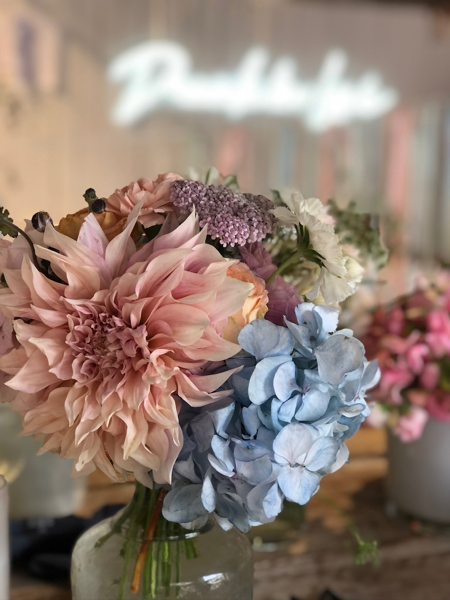 Blumenstrauß mit Dahlien, Hortensien und anderen Blumen in einer Glasvase
