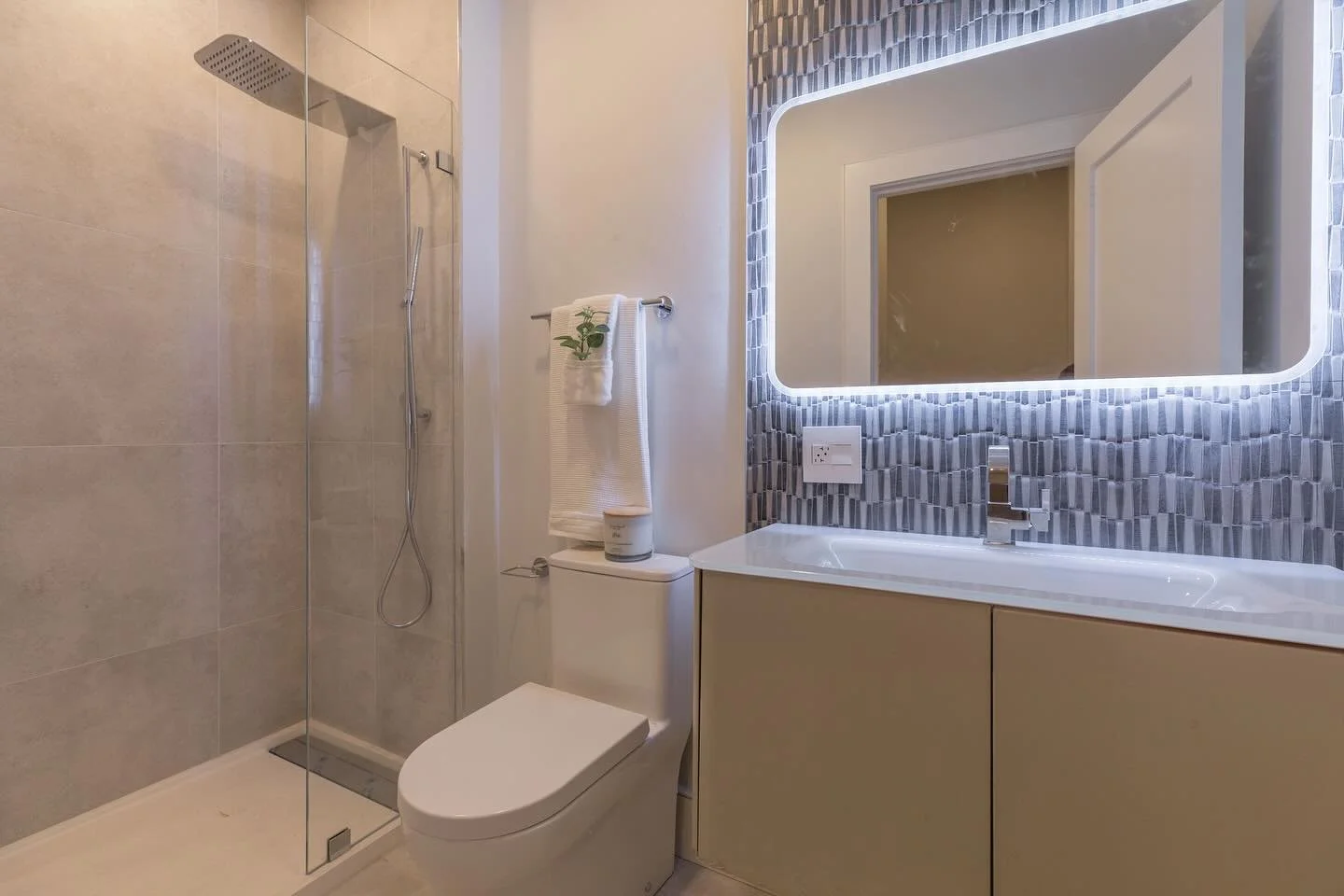 Enter a retreat where every detail is crafted for comfort and style. Subtle lighting sets a serene mood while bold geometric tiles create a striking backdrop behind the vanity. This is where daily routines feel effortless and a sense of calm luxury g