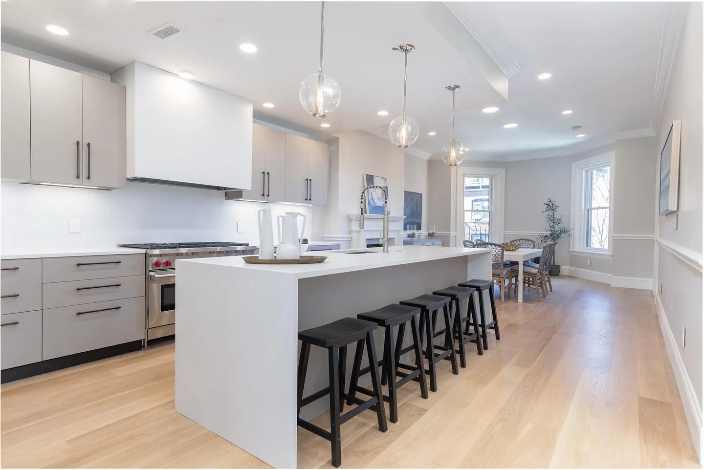 A balance of warmth and refinement. This contemporary penthouse kitchen unfolds into an open dining area, where soft neutrals and natural light create an atmosphere of quiet sophistication. Each detail was chosen to complement the historic charm of t