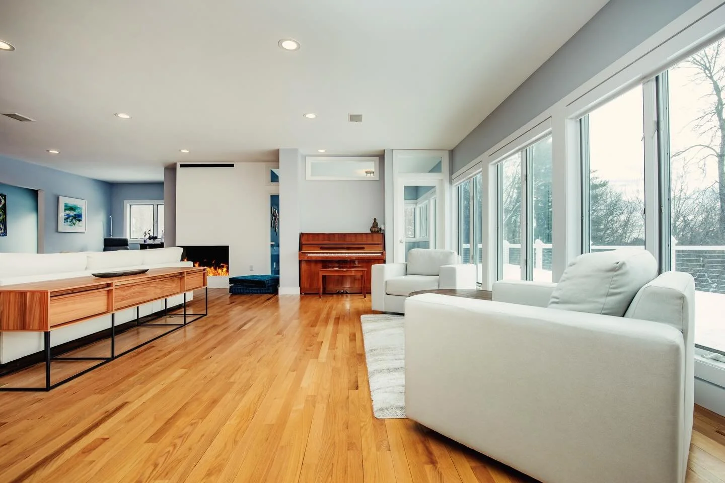 Living room design that blends openness, function, and refined comfort. This project reimagines the layout with thoughtful space planning, a restructured fireplace focal point, and a private office filled with natural light. A dedicated piano nook ad