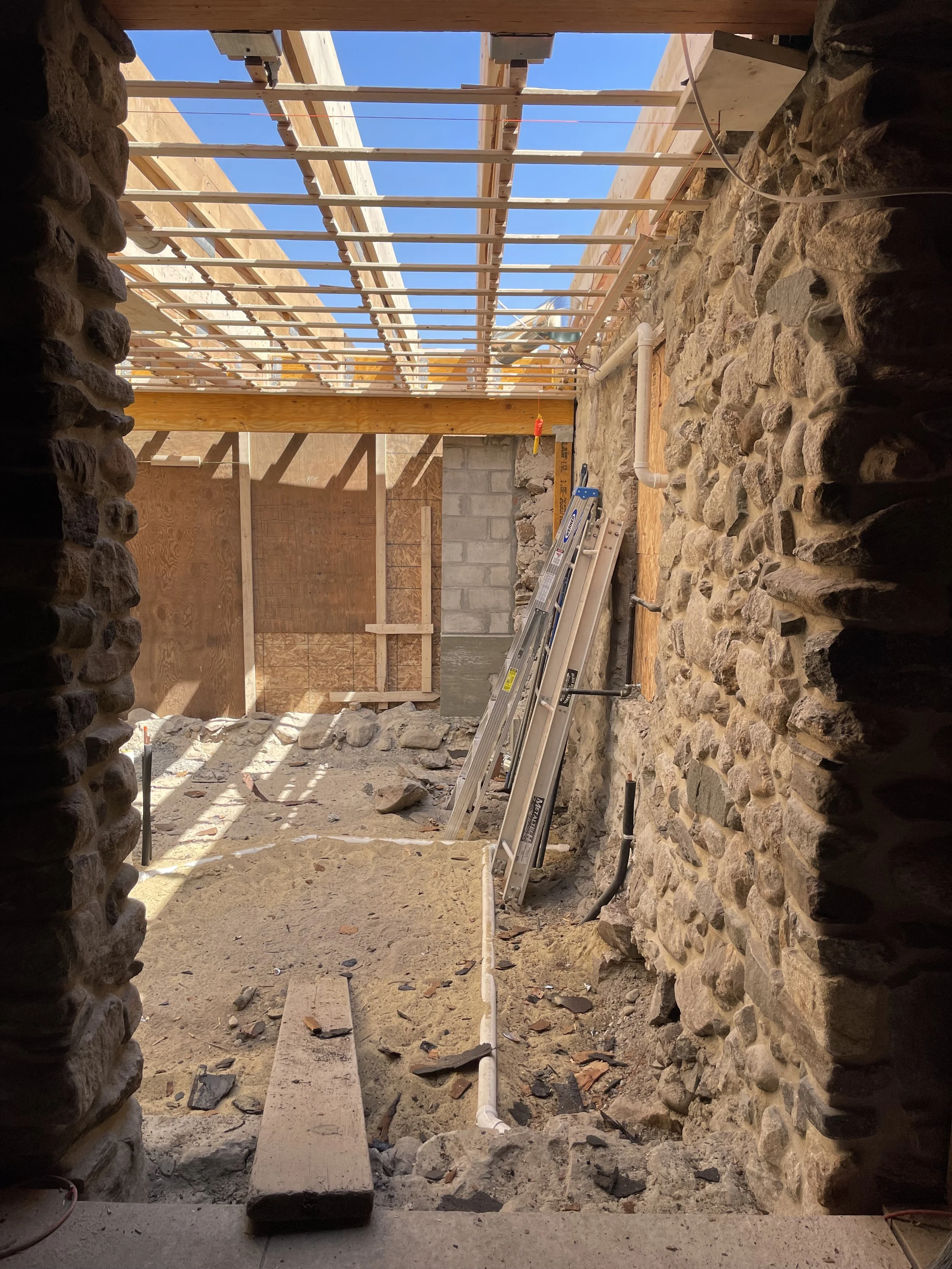Demolition of slate floor along with 3 slabs beneath. New framing underway at roof. The demolished roof framing was sagging which caused pooling on the old roof. Rough plumbing underway to turn this beauty into a proper kitchen with radiant heat.