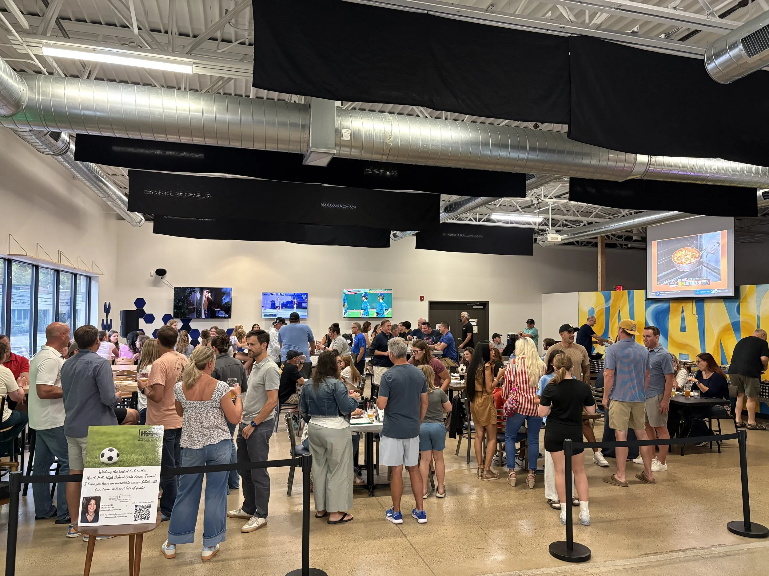 a photograph of a crowded tap room filled with people participating in a fund raiser 