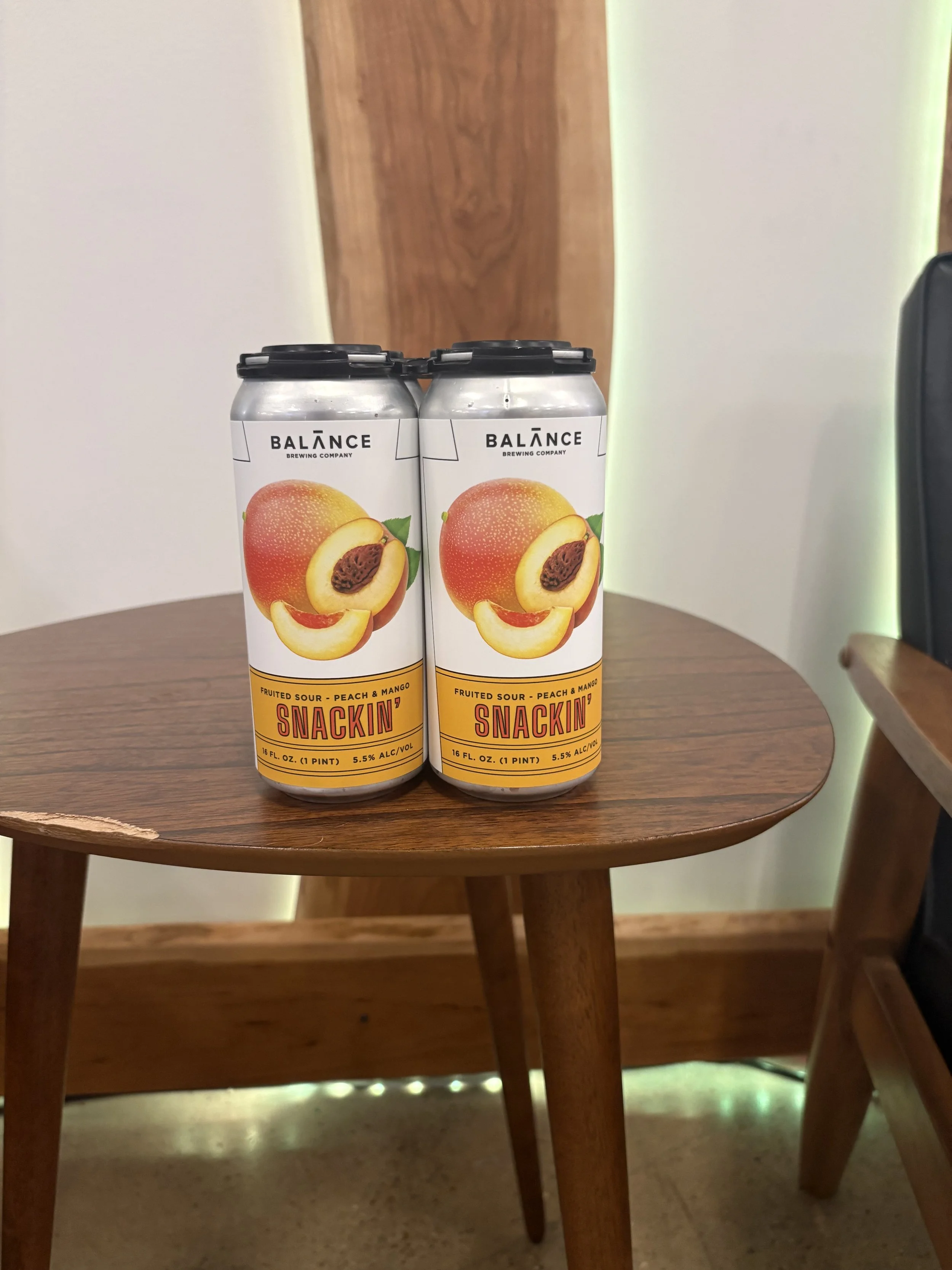 4 orange and white beer cans on a wooden table.