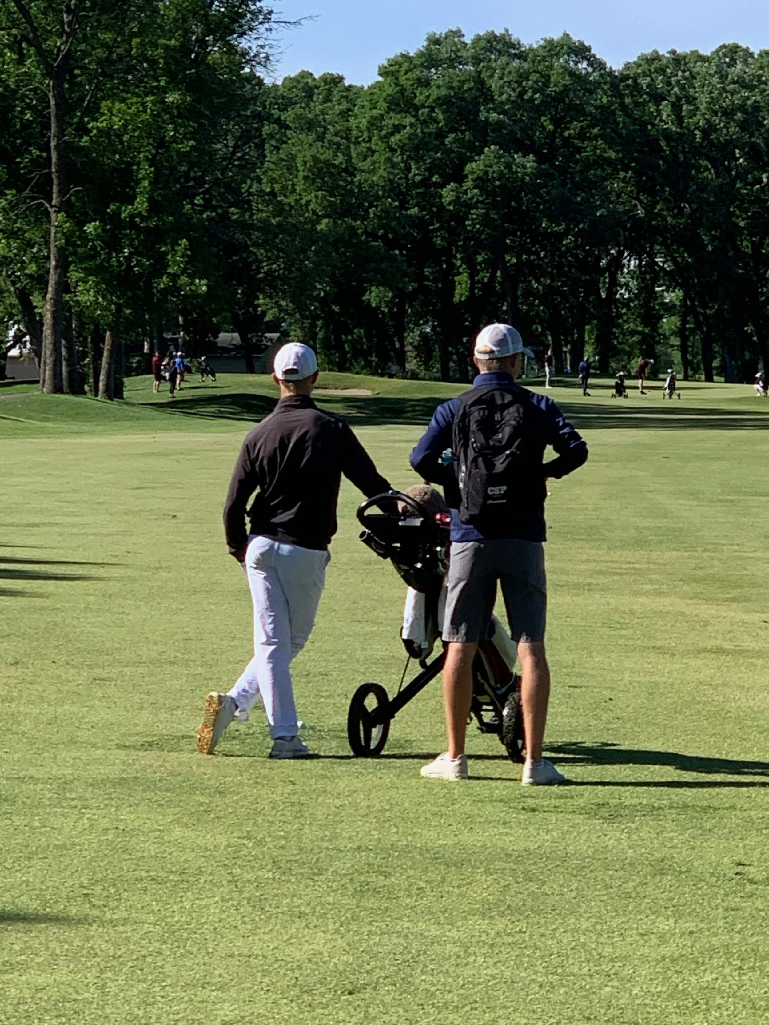 Caleb caddying for a junior golfer at the Minnesota State High School League Tournament.