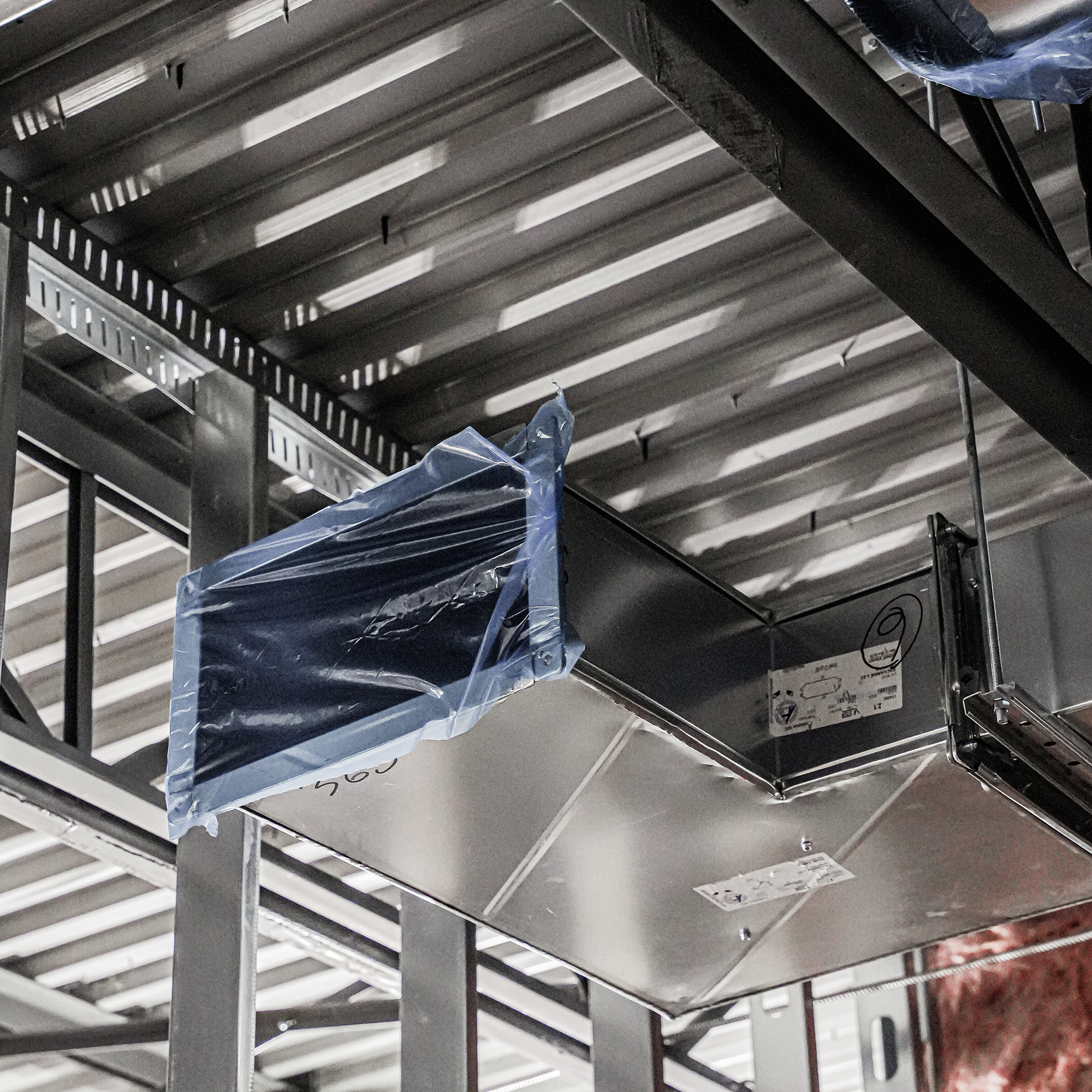 Étageres en métal avec des boîtes et des emballages en plastique, semblant être dans un entrepôt ou un stock.