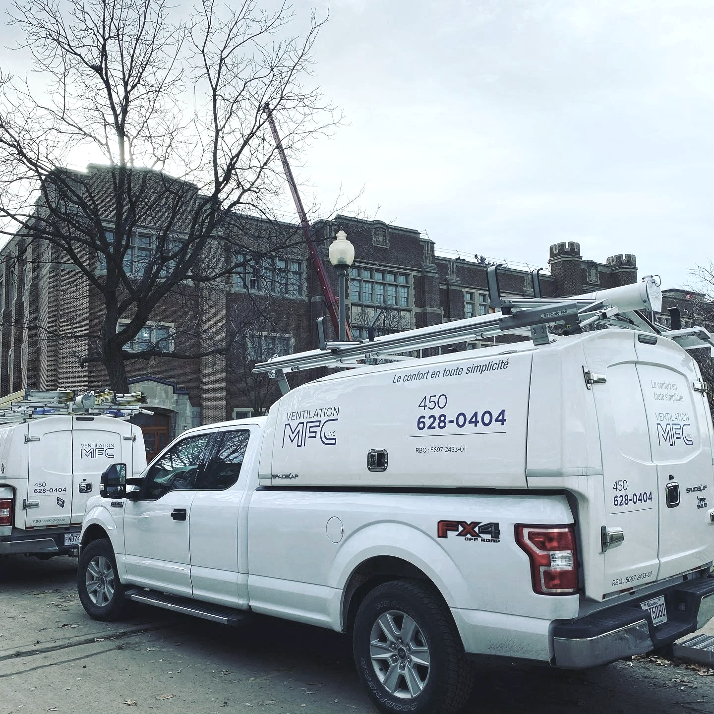 Camion de ventilation blanc Ventilation MFC stationné sur une rue devant un bâtiment