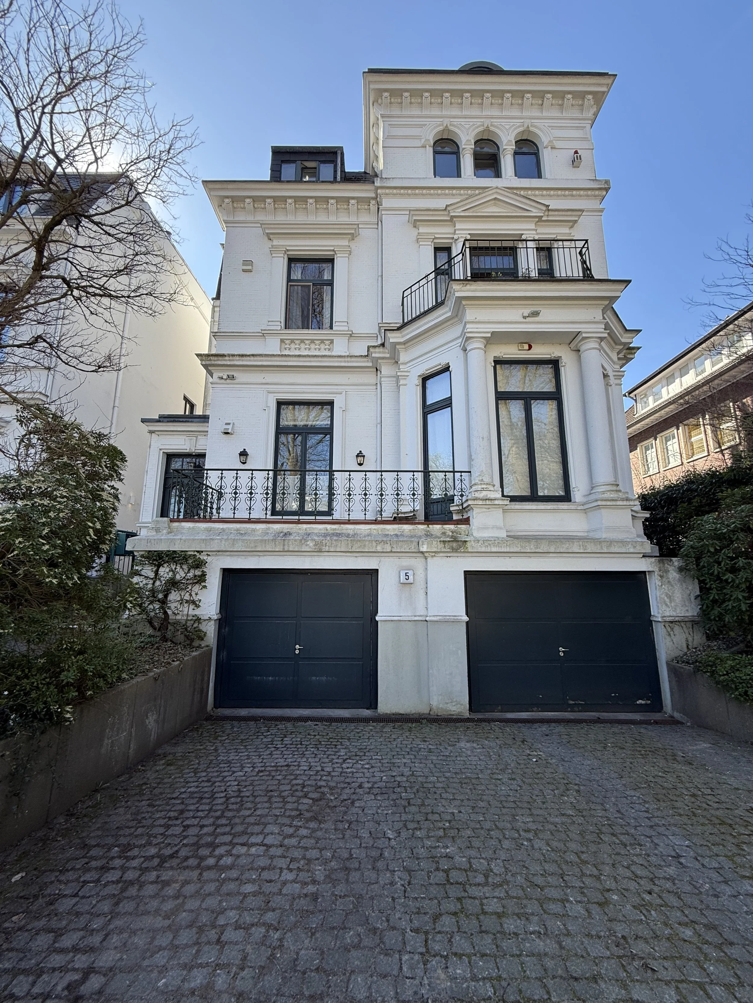 Straßenansicht einer historischen Stadtvilla mit gegliederter Putzfassade und Balkonen, die von SVH Architekten saniert und im Dachgeschoss umgebaut wurde.