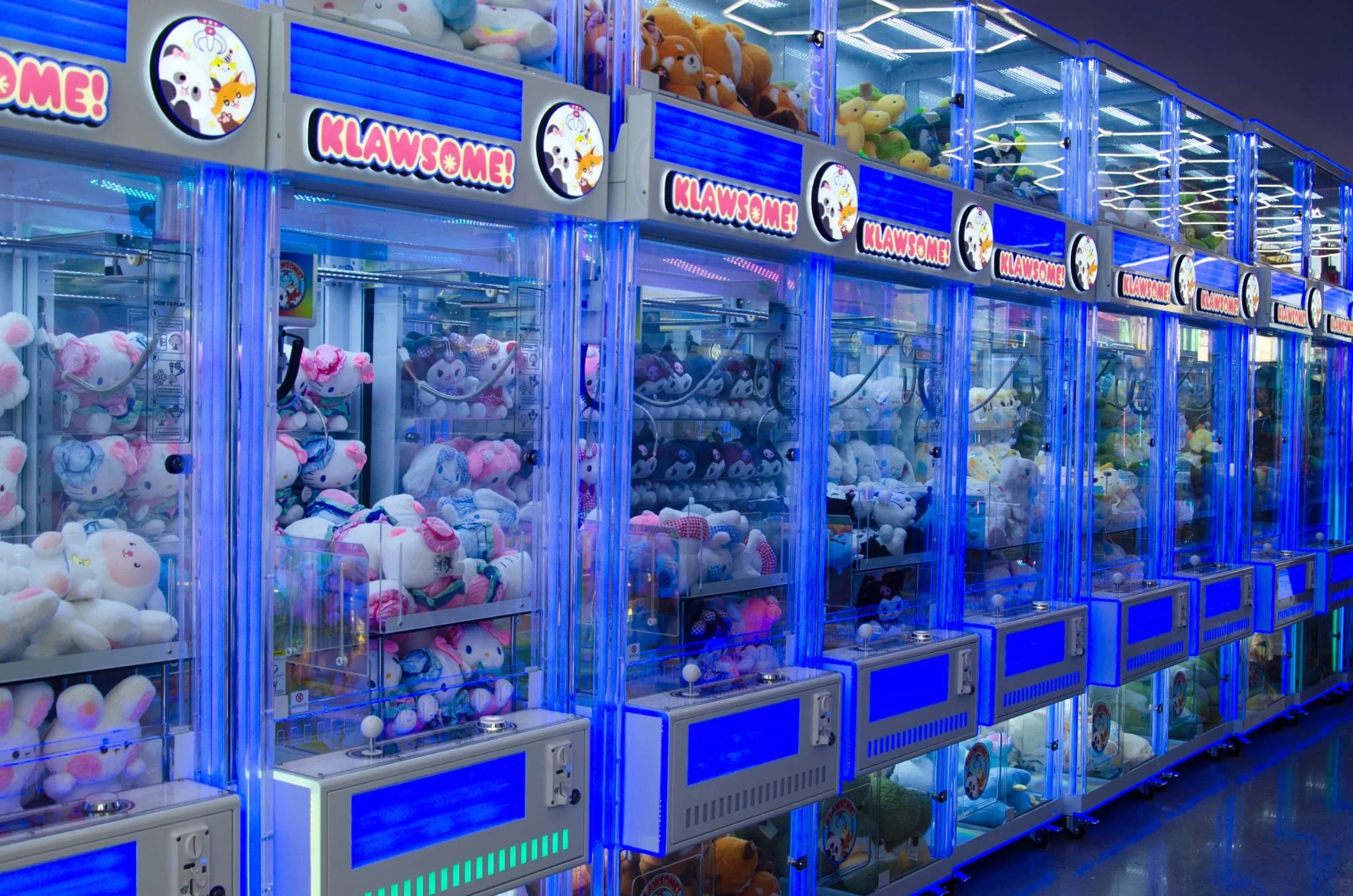 Guests watching a claw machine at Klawsome before playing