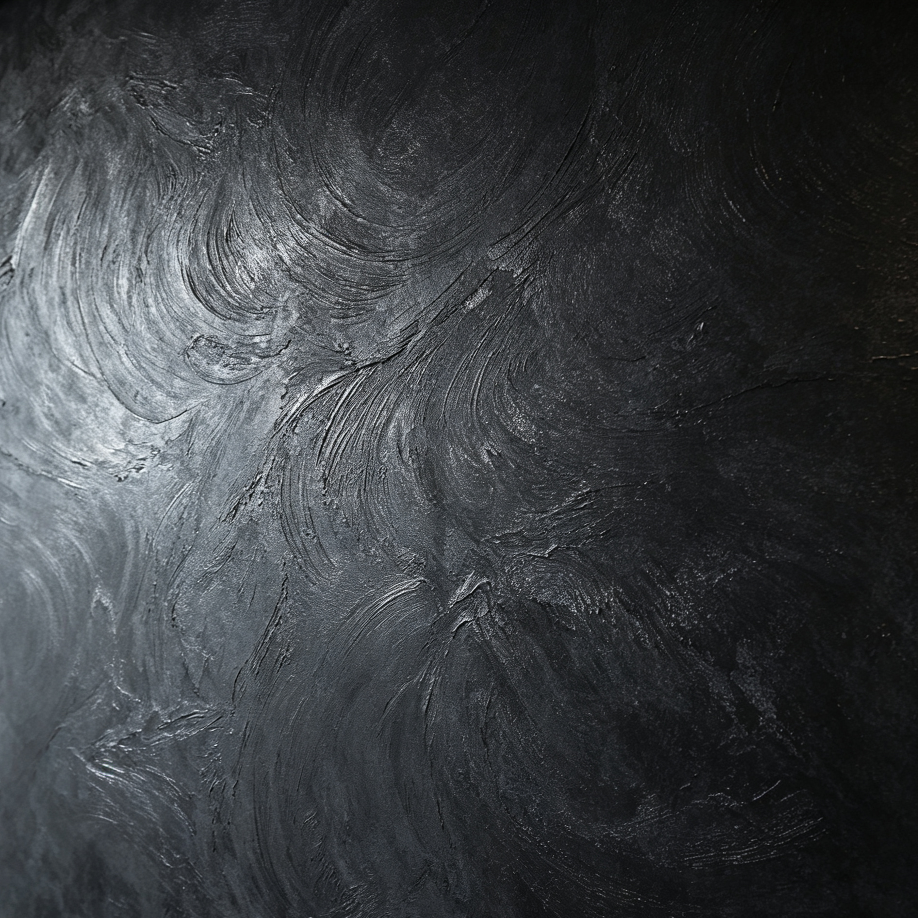 Close-up view of a black textured surface with visible brush strokes and swirling pattern.