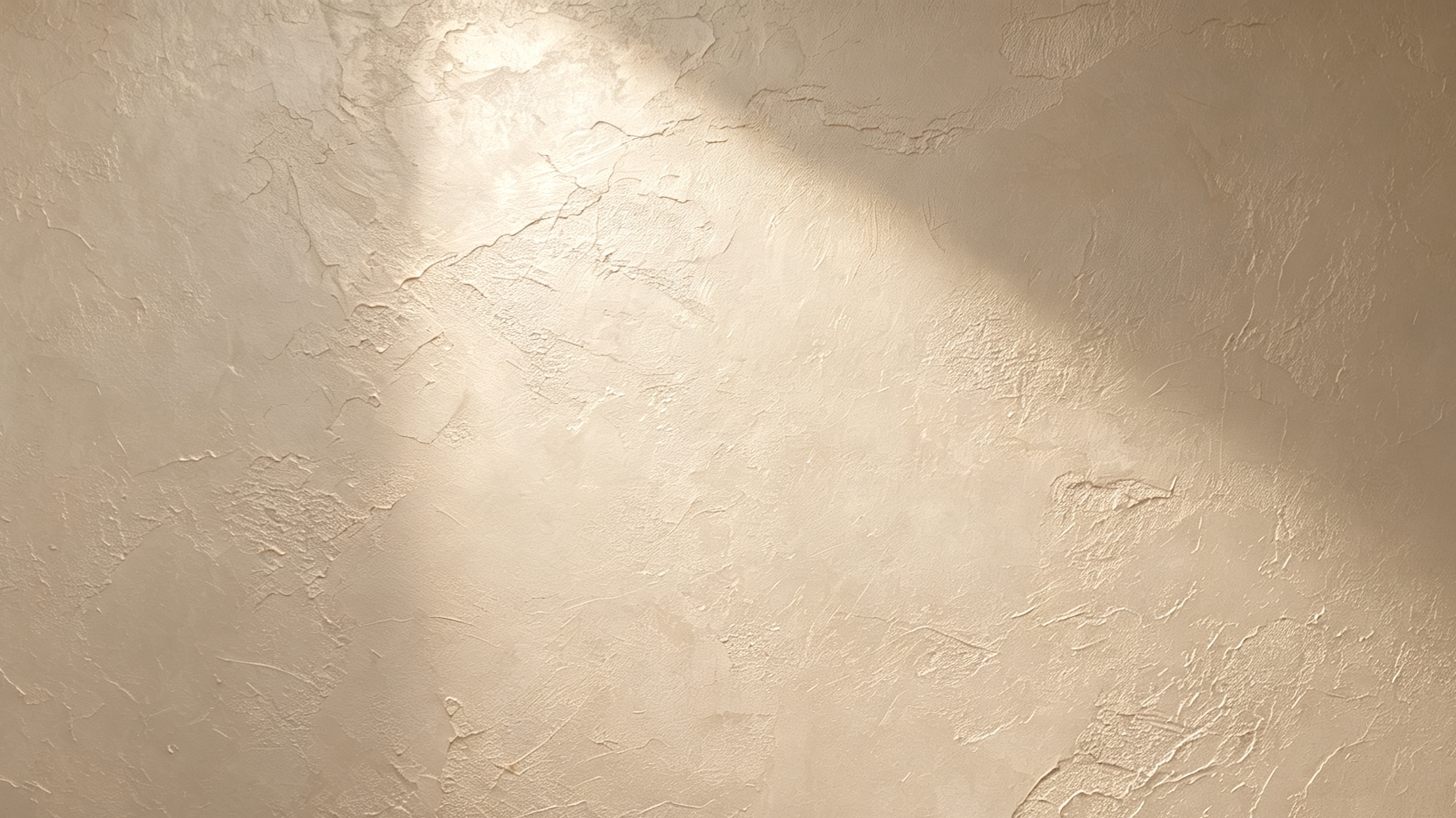 A textured beige wall with irregular painted patterns and shadows.