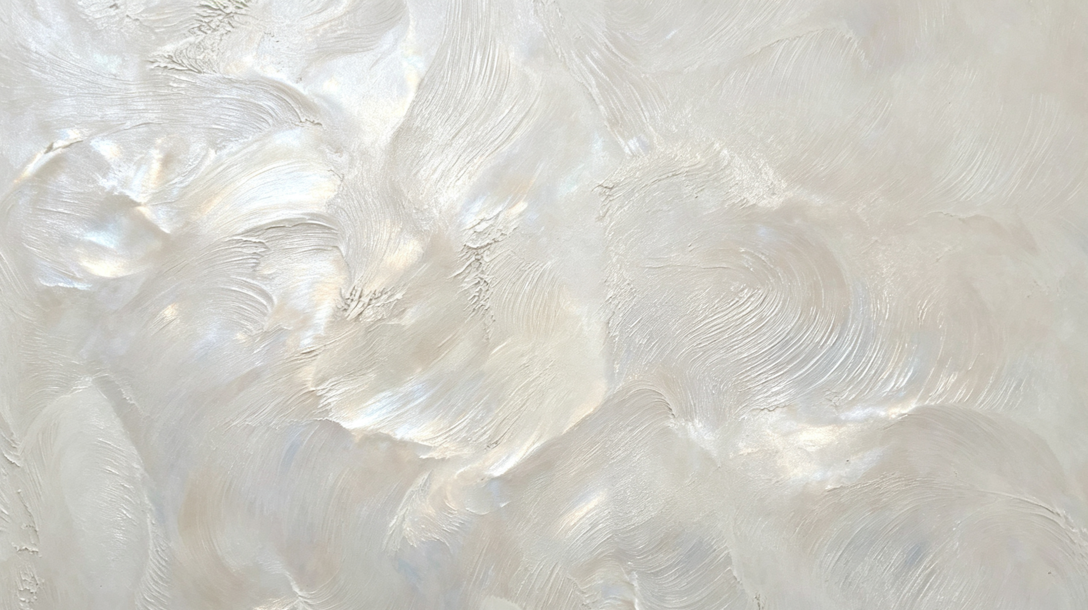 Close-up of a textured, cream-colored wall with swirling patterns and glossy finish.