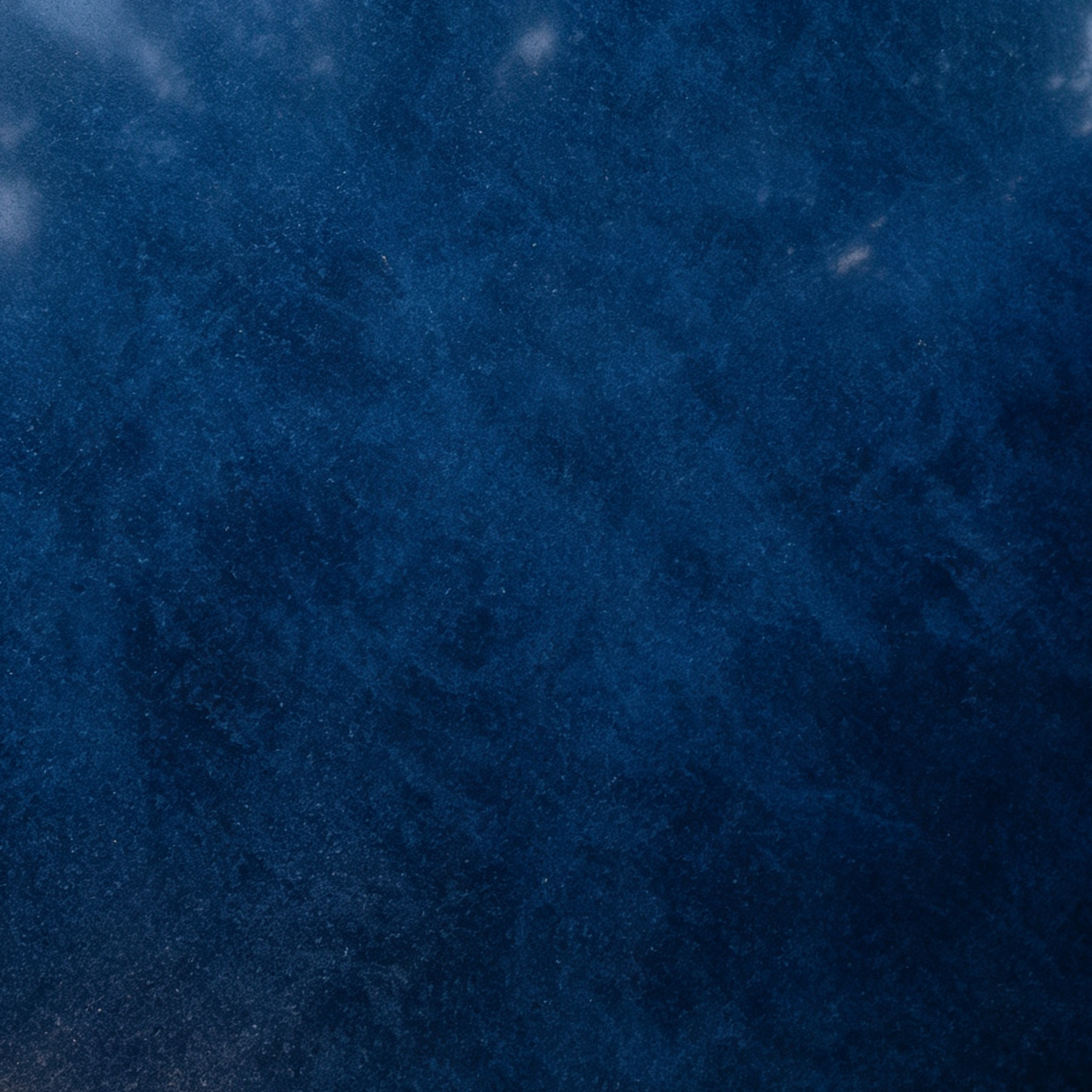 A close-up image of a dark blue, textured, snowy surface.