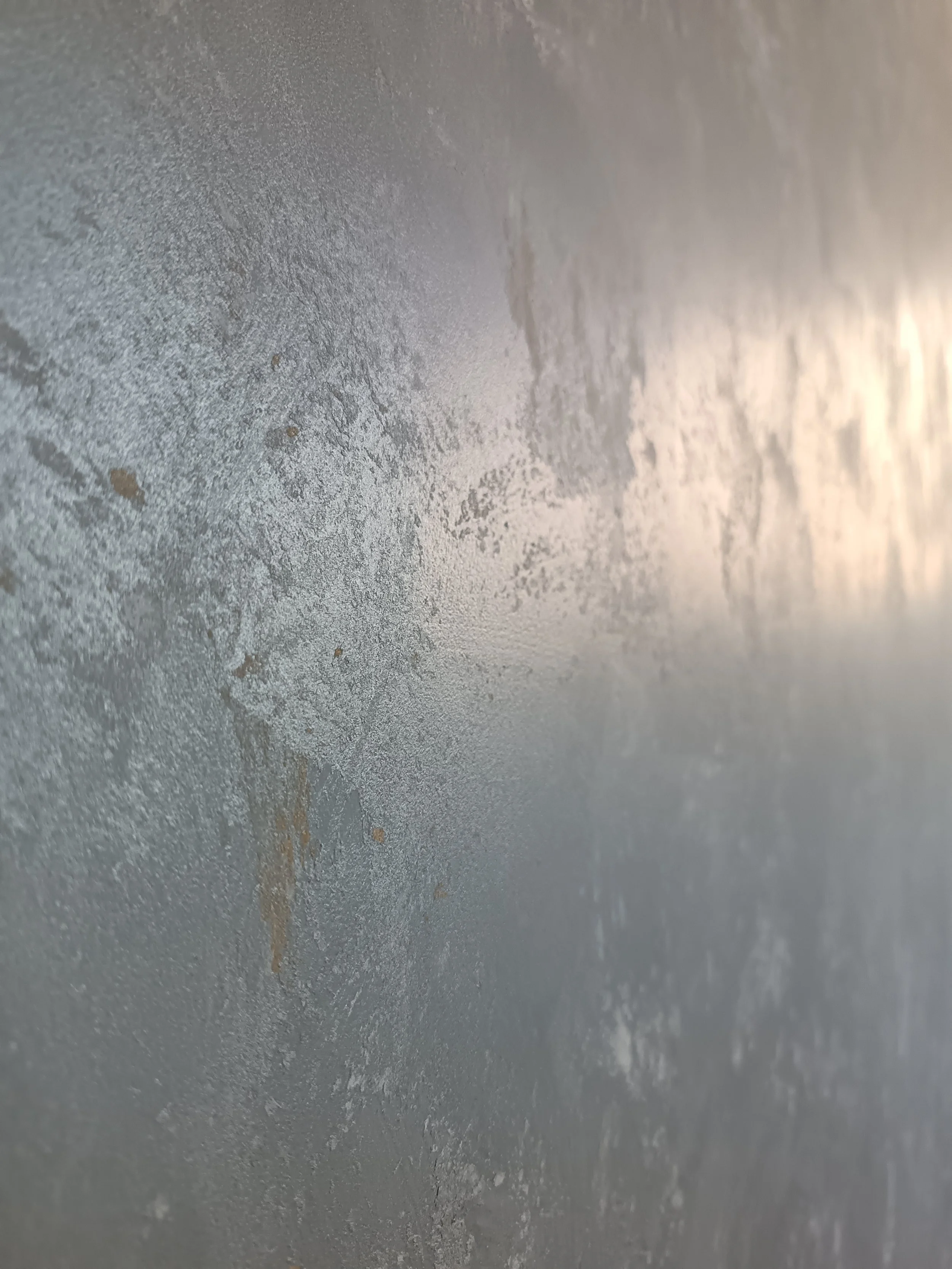 A close-up of a green surface with a line running across it, featuring small reflective spots and some imperfections.
