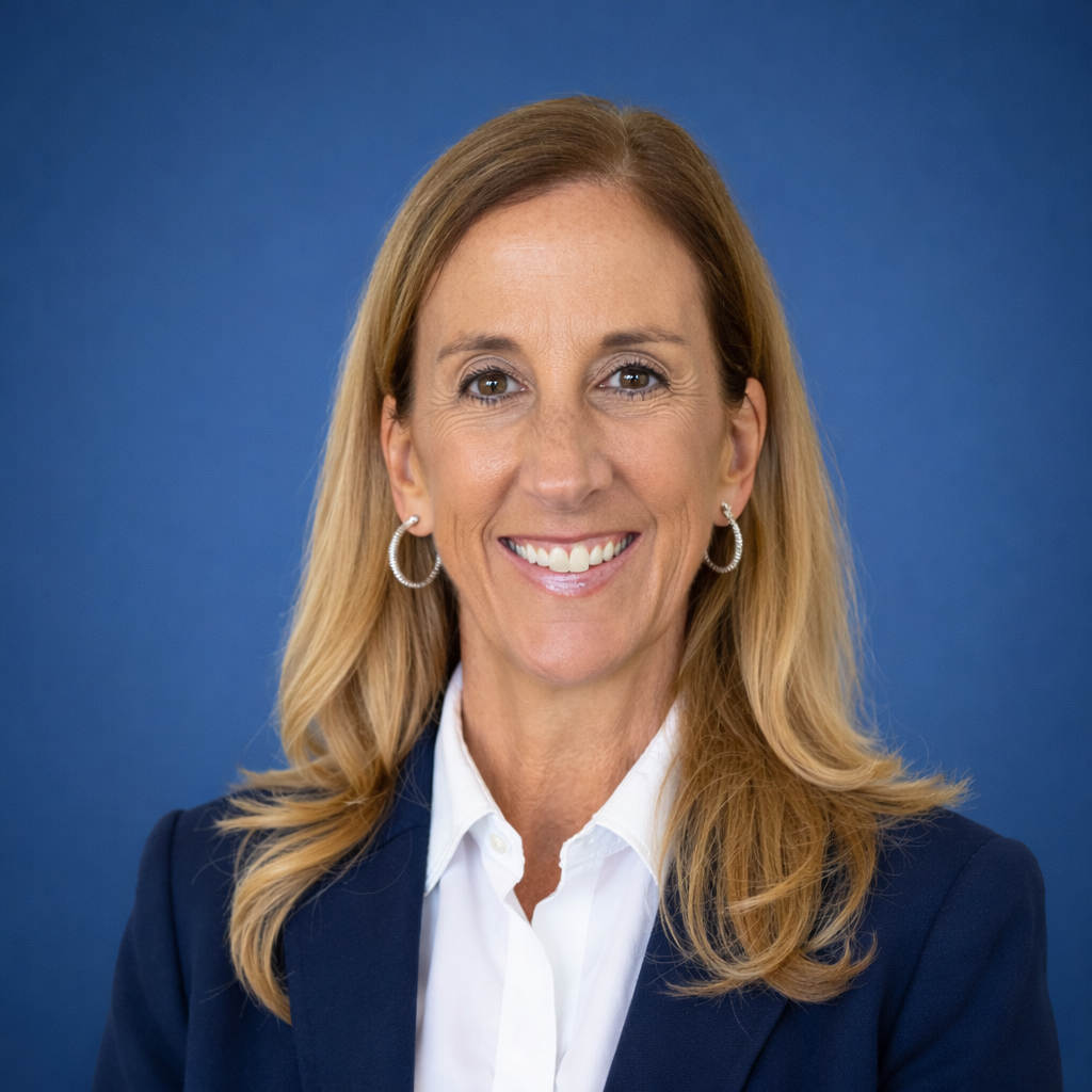 Smiling person with shoulder-length hair in a black and white photo