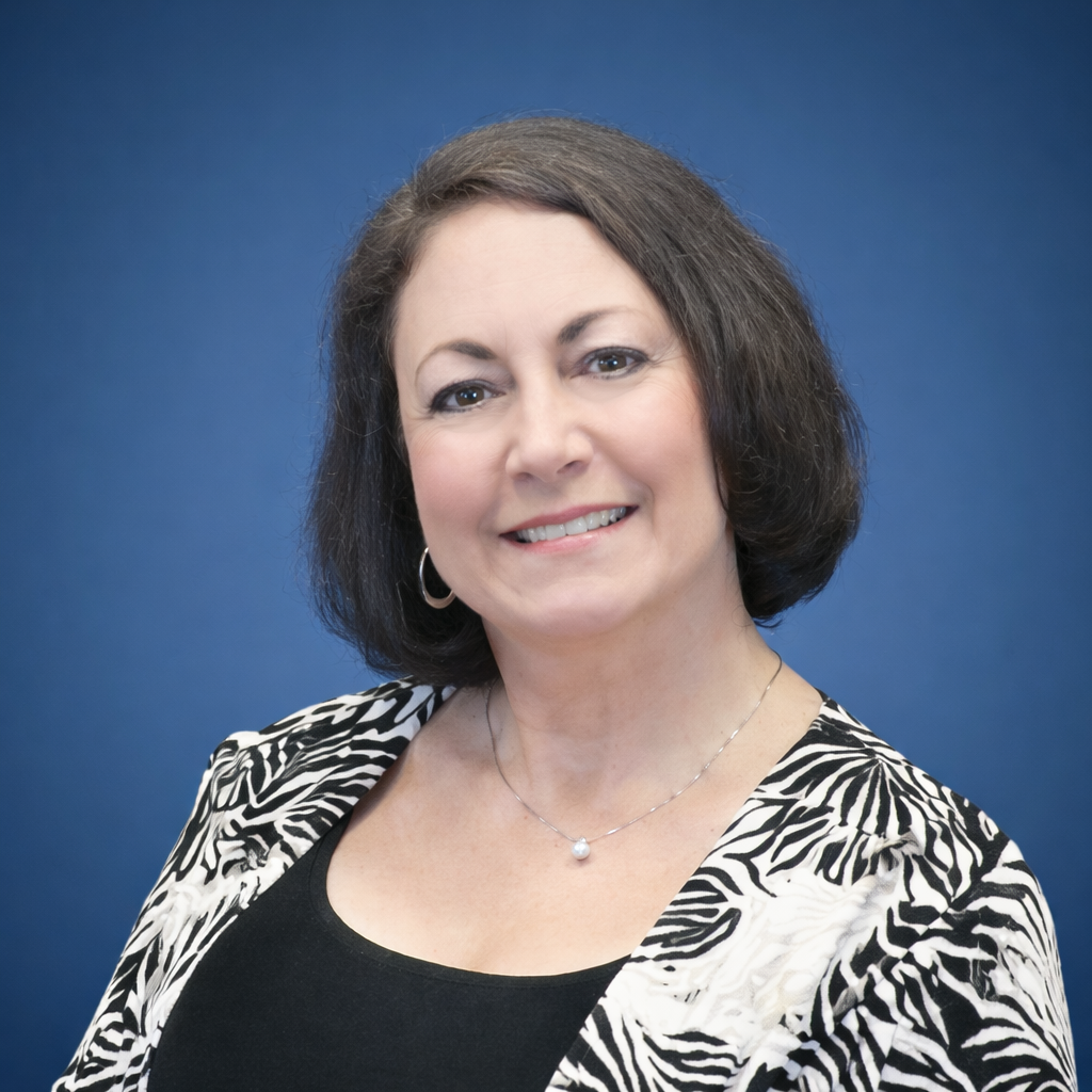 Woman smiling in front of bookshelf, black and white photo