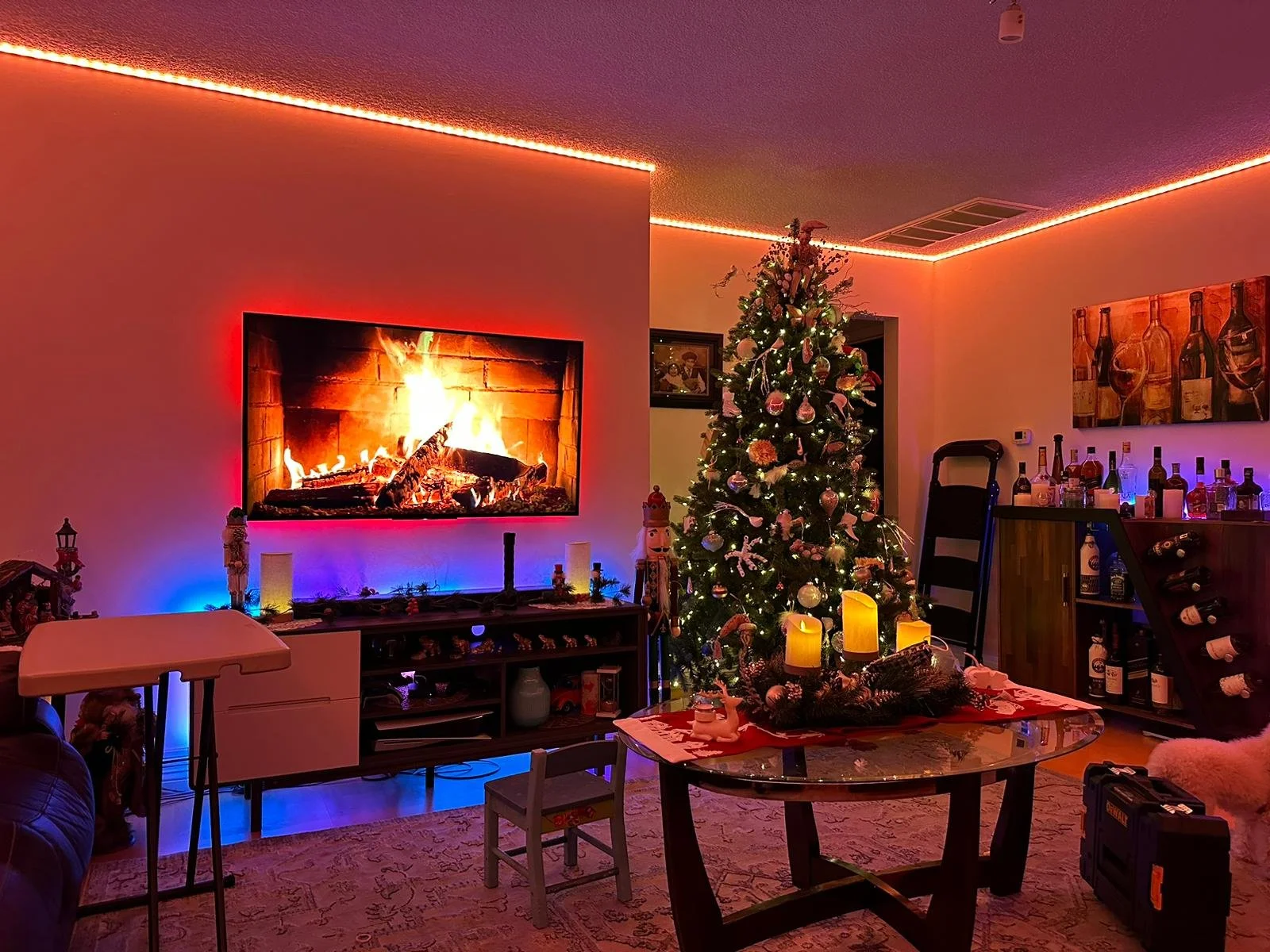 Decorated Christmas living room with a Christmas tree, fireplace, and colorful lighting.