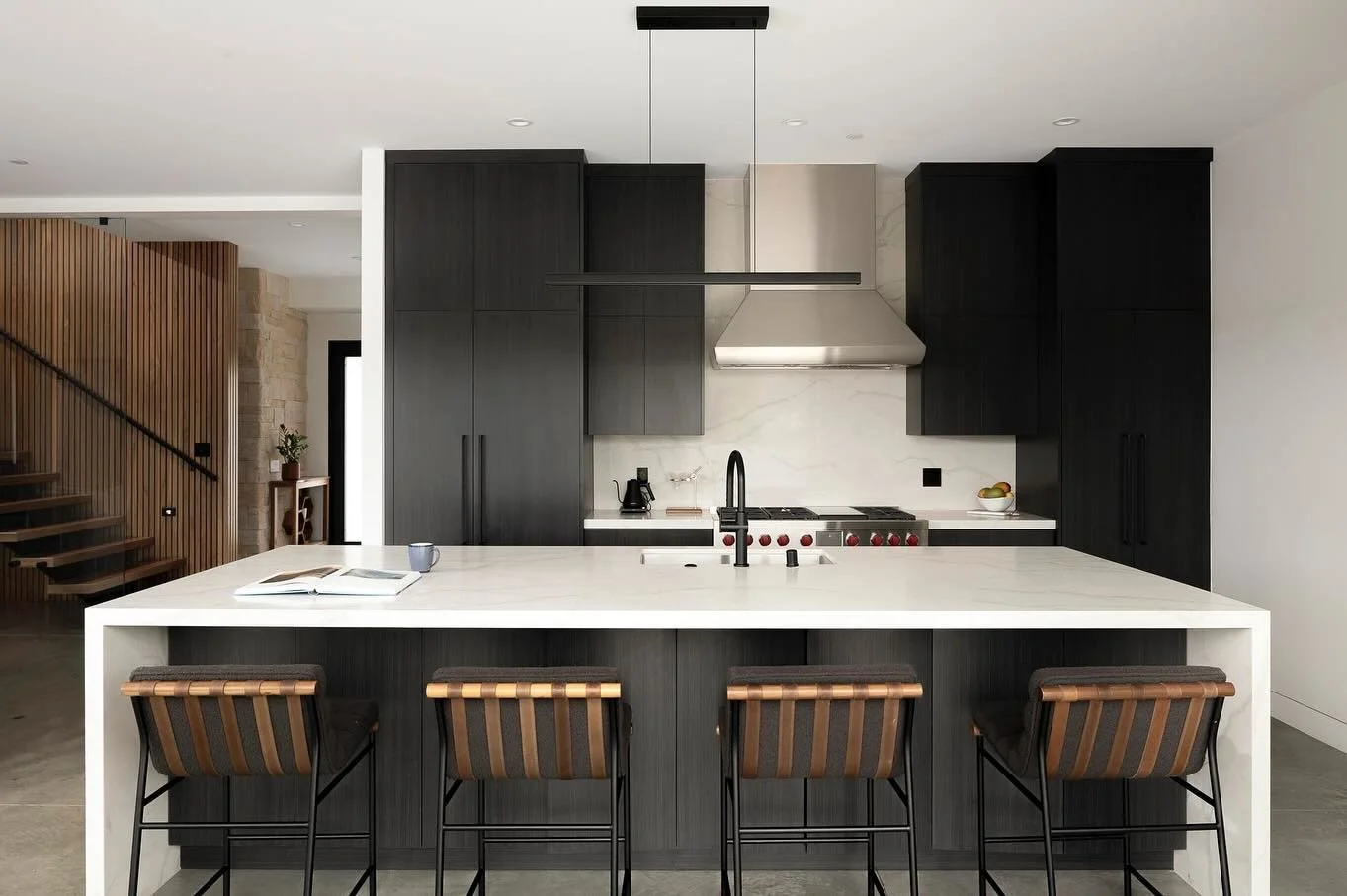 A paneled in sub zero fridge on the left and a hidden walk in pantry on the left are the twin stars of this chefs  kitchen.