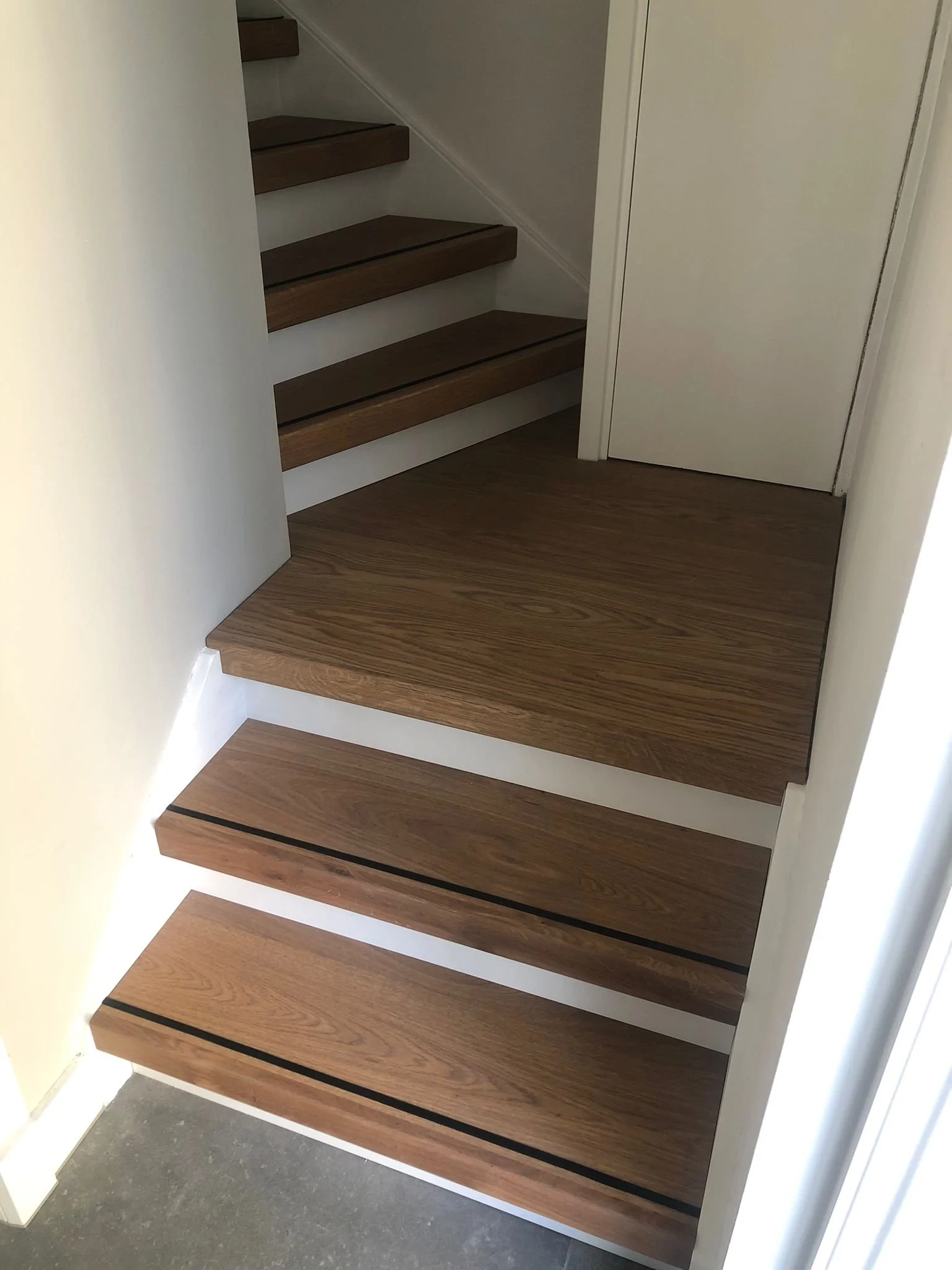 Binnen trappen met houten treden en witte zijwanden, in een huis.