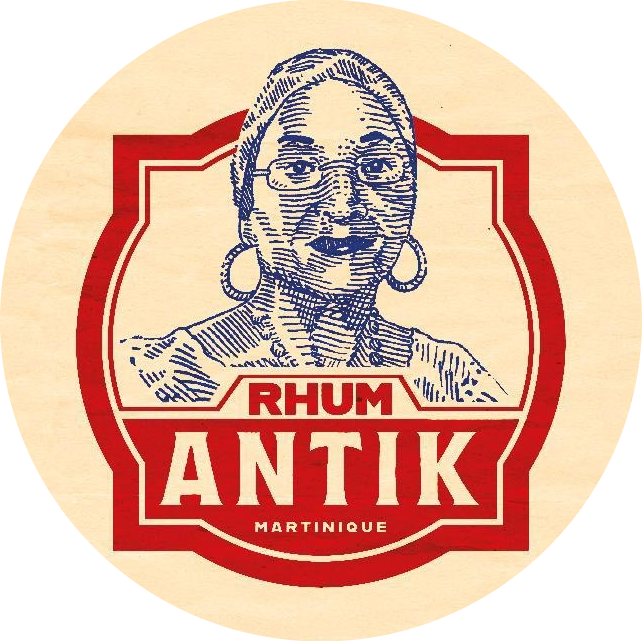 Logo d'un portrait style sketch d'une femme portant des lunettes et de grosses boucles d'oreilles, avec le texte « Rhum Antik Martinique » en rouge et blanc.