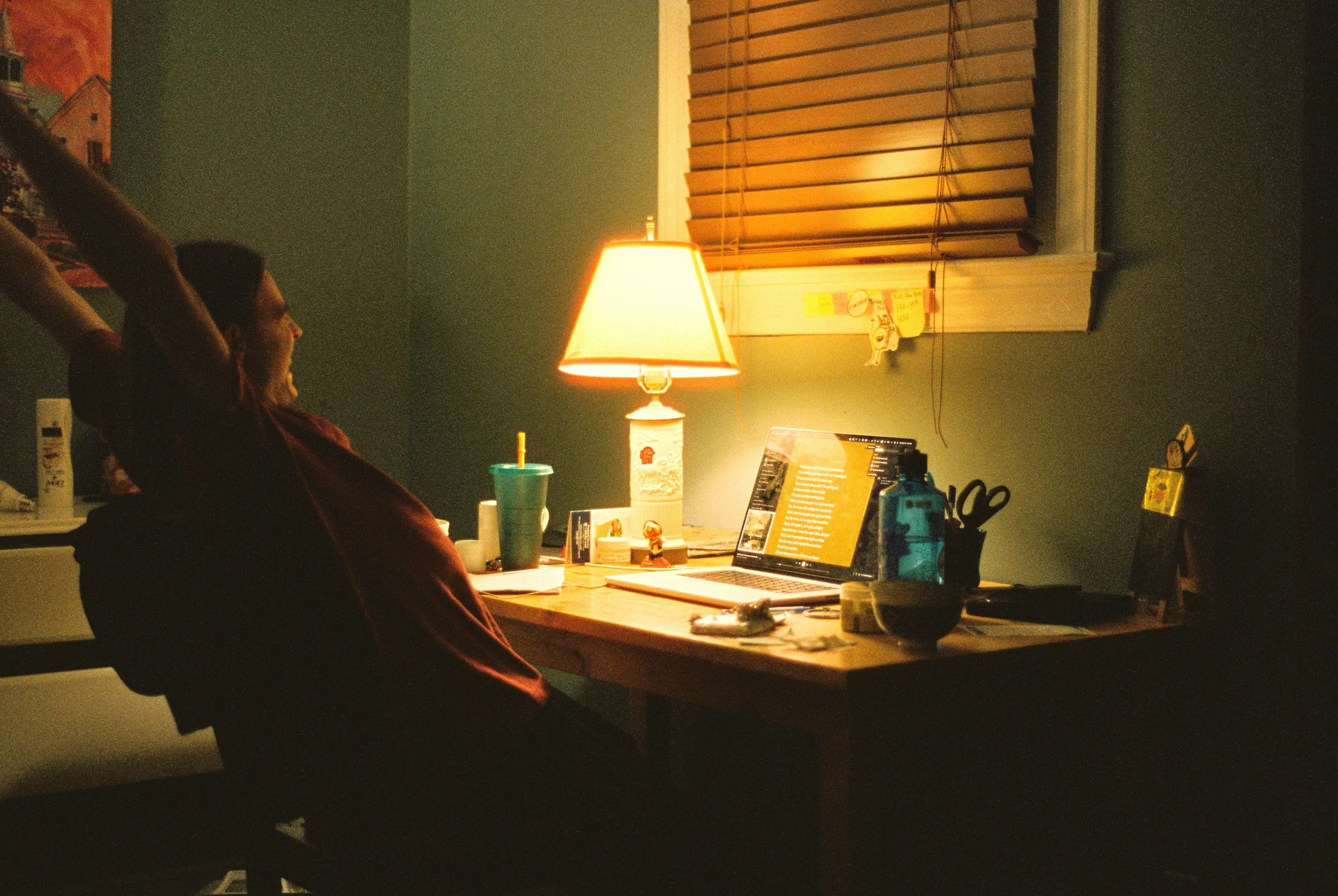 Woman stretching and cheering behind a desk