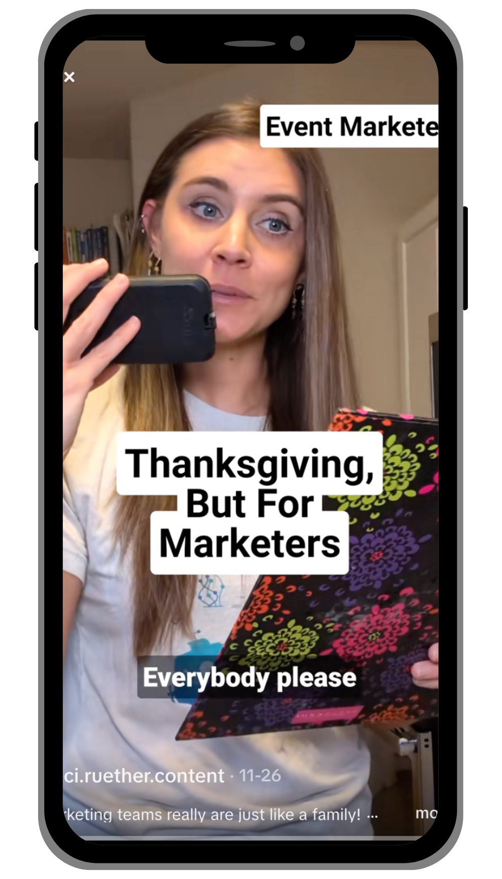 A woman holding a clipboard and on her phone with a clipboard that says 'Thanksgiving, But For Marketers'