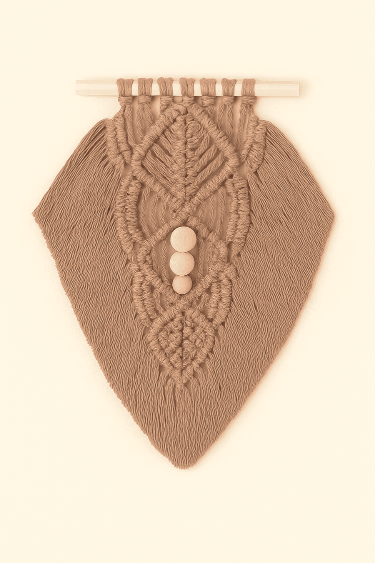 Earthy-toned macramé wall hanging in light brown yarn with detailed knotwork and wooden beads, flat lay style on beige background.