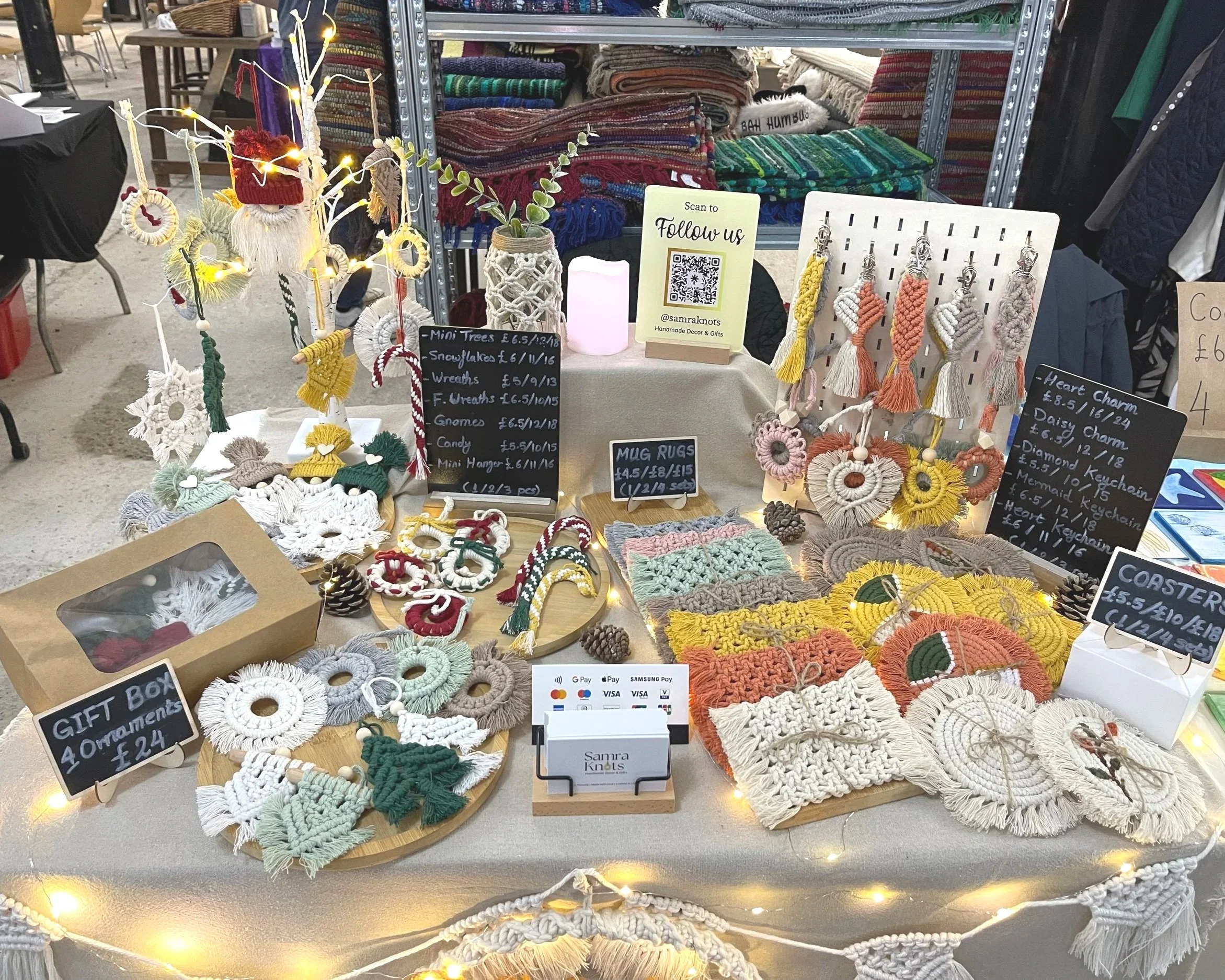 Handmade macramé coasters, ornaments, and accessories displayed at a craft market stall.