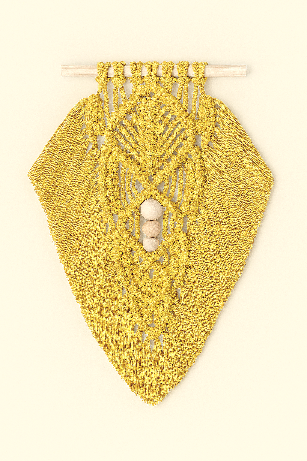 Bright mustard yellow macramé wall hanging with layered leaf pattern and natural wood beads, hanging on light neutral surface.