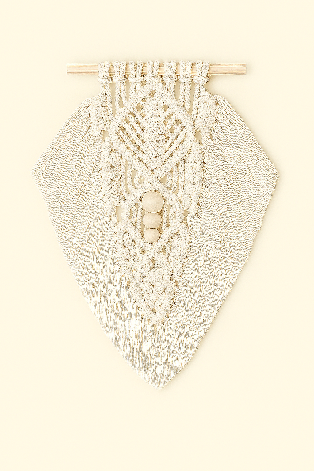 Handmade macramé wall hanging in off-white cotton with intricate leaf pattern and wooden beads, styled on warm beige background.