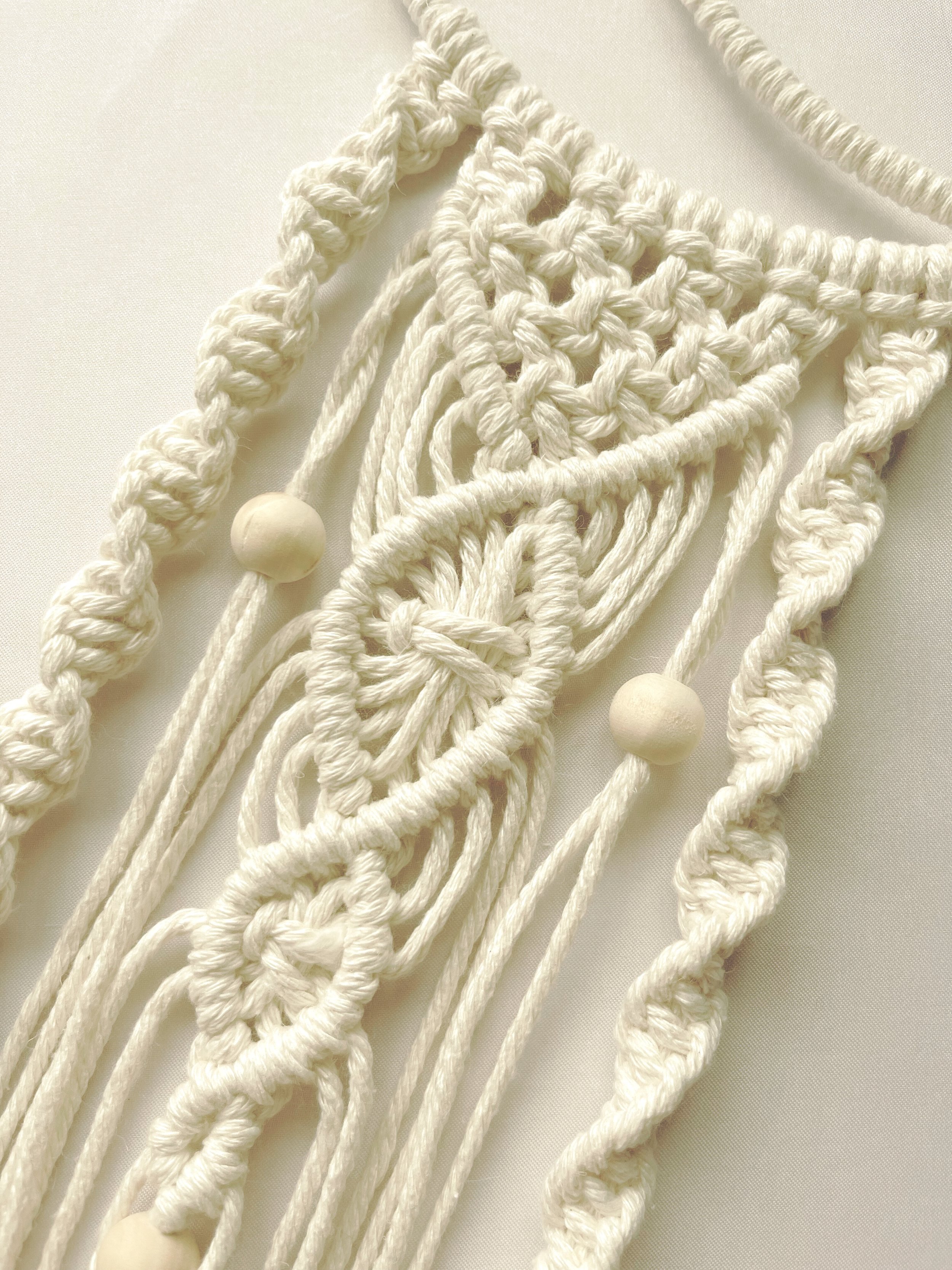 Close-up of handmade macramé crescent moon wall hanging with intricate cotton knots and wooden beads – Islamic boho decor by Samra Knots