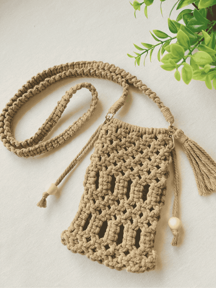 Full handmade macramé crossbody phone bag in light brown with boho-style strap and tassels