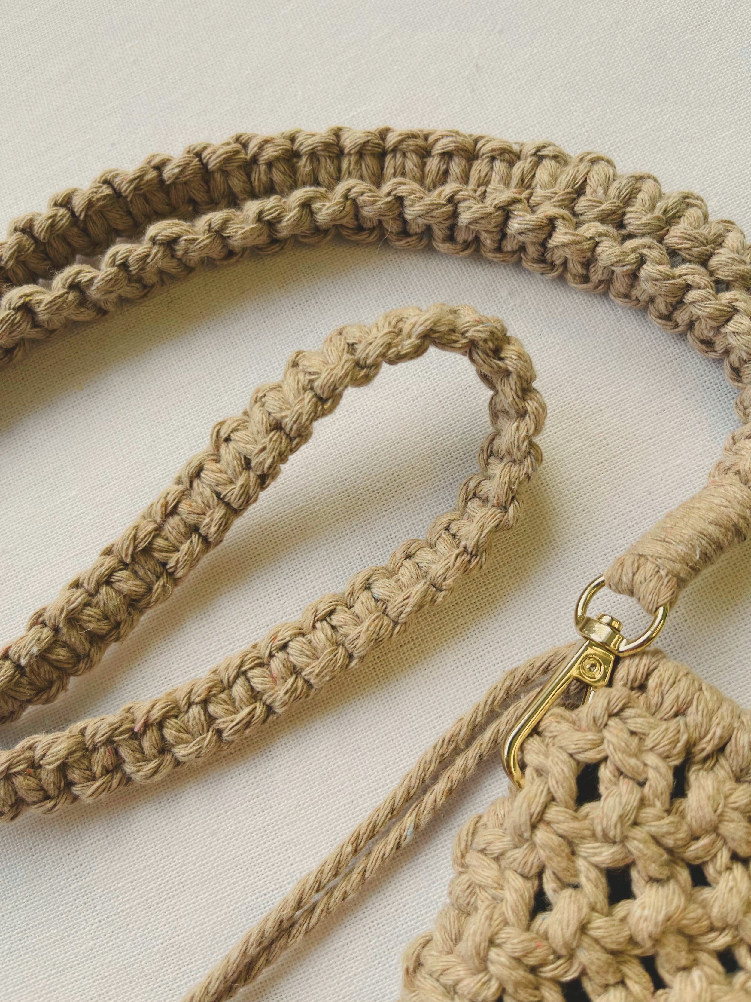 Braided cotton strap and gold clasp detail of macramé phone bag in light brown cord