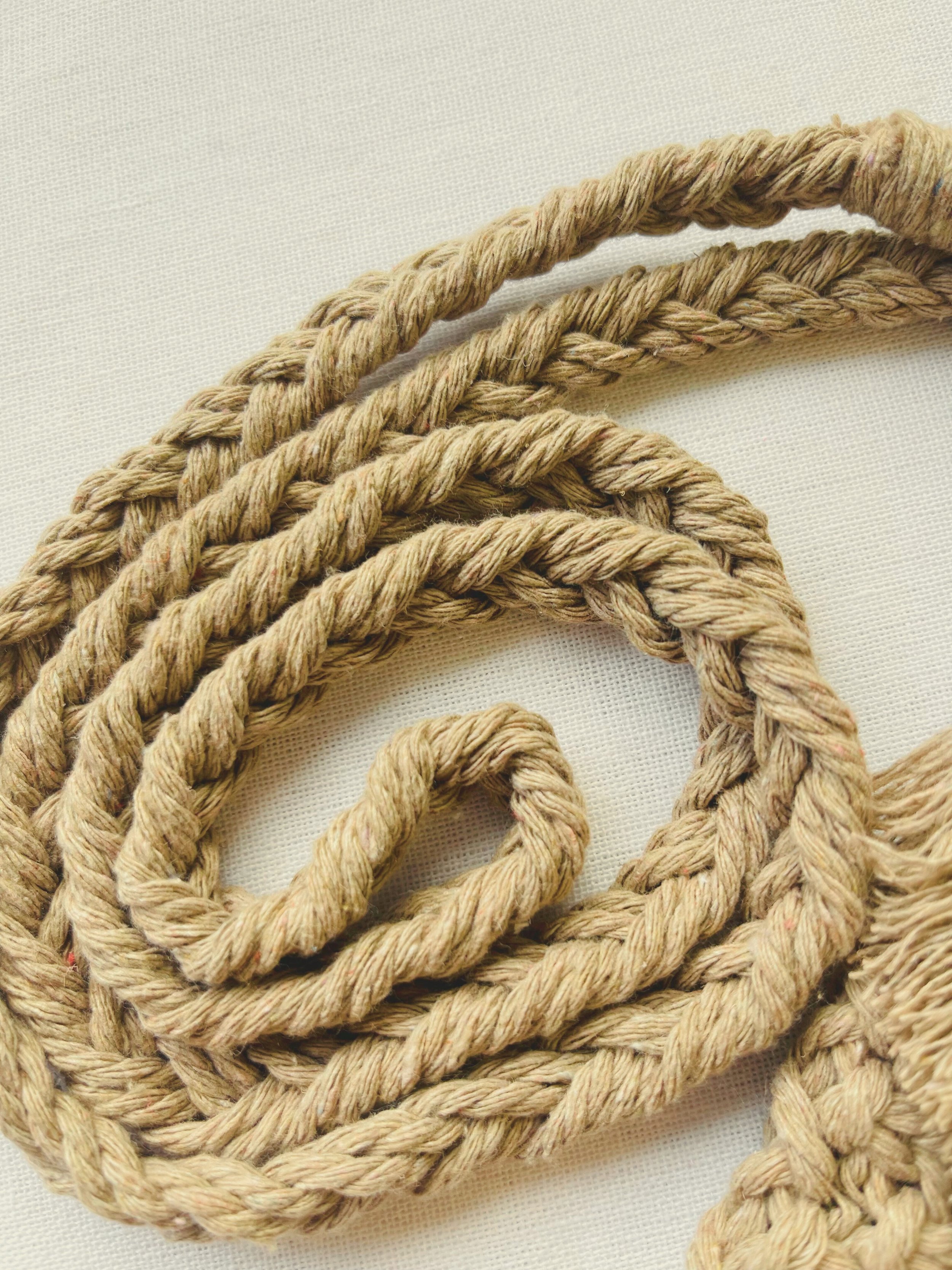 Close-up of the light brown cotton macramé strap showing intricate braided design and soft fibre texture.