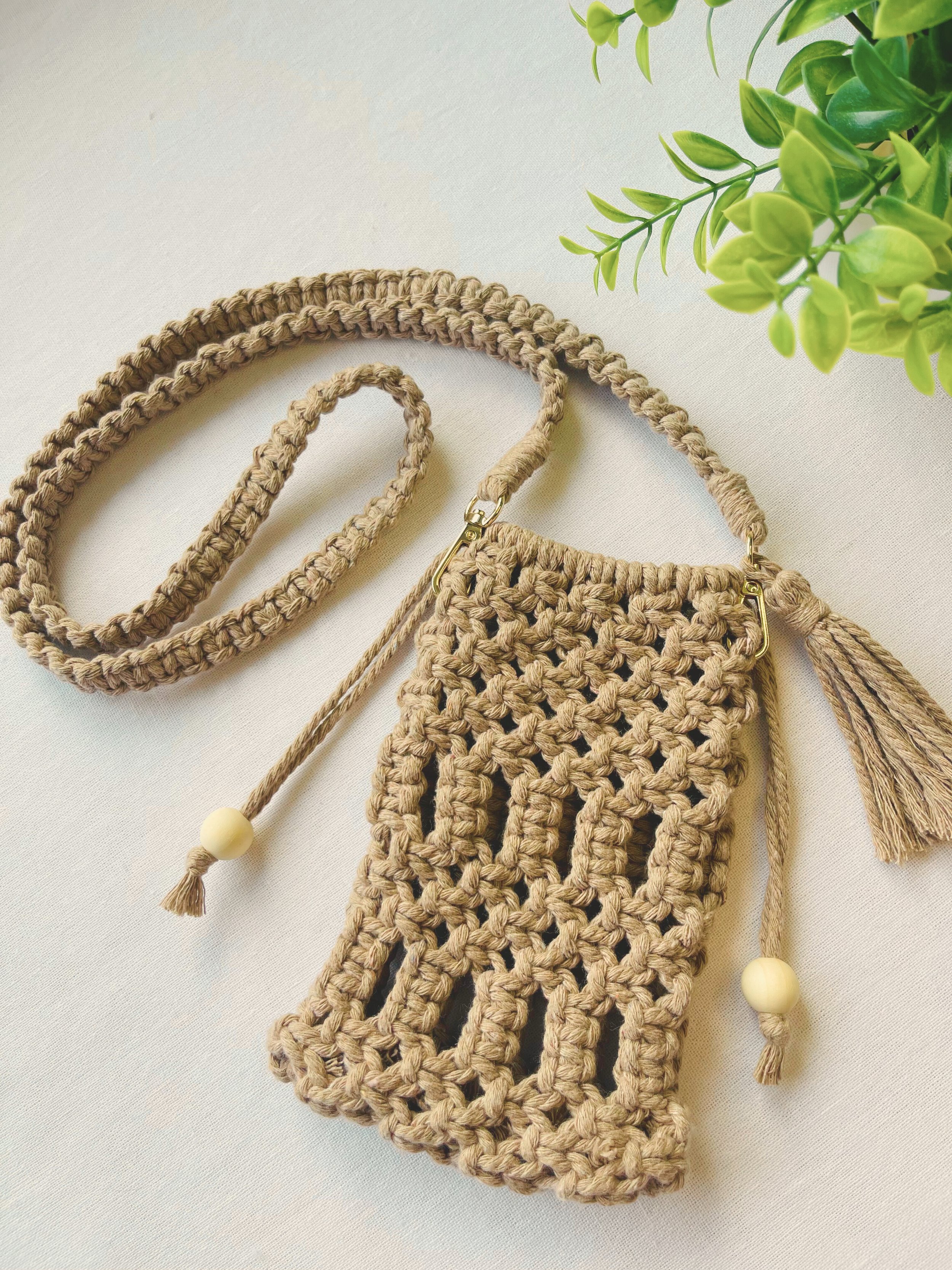 Full handmade macramé crossbody phone bag in light brown with boho-style strap and tassels