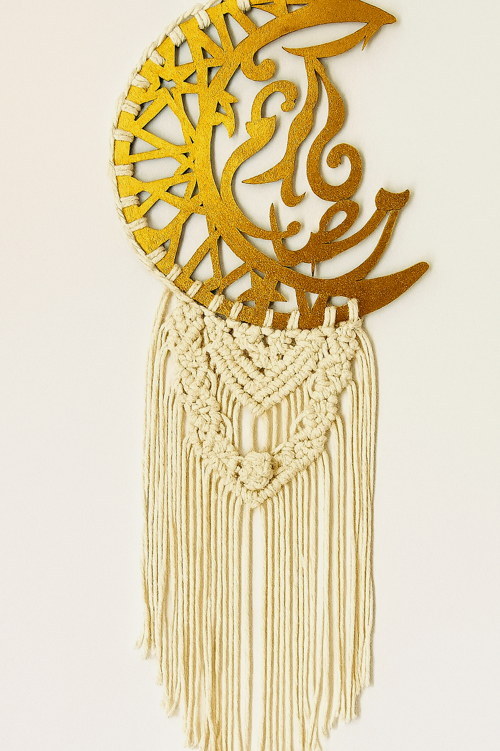 Handmade Islamic macramé wall hanging with gold crescent ayah plate and off-white cotton fringe, styled against a soft off-white background – Samra Knots.