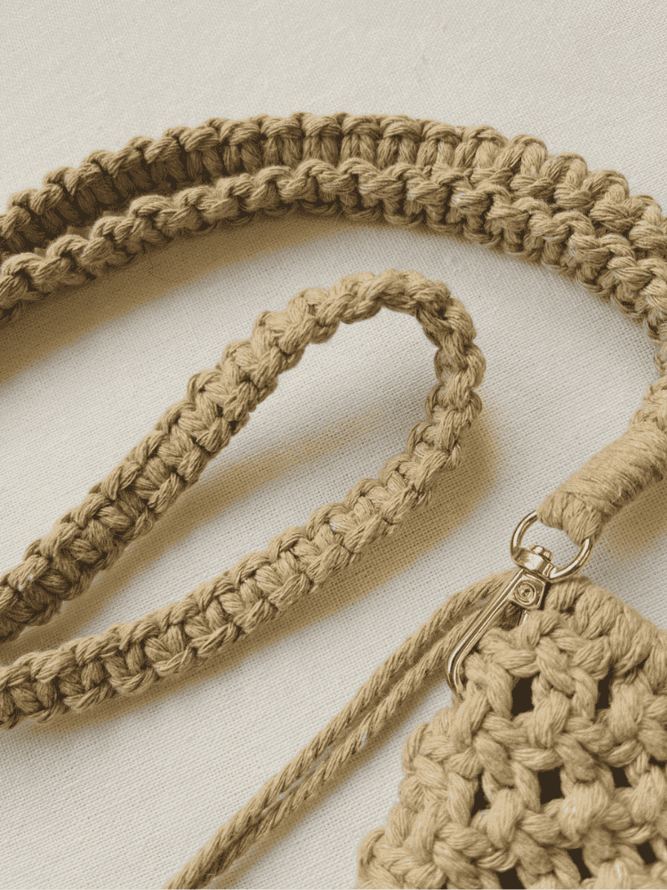 Braided cotton strap and gold clasp detail of macramé phone bag in light brown cord