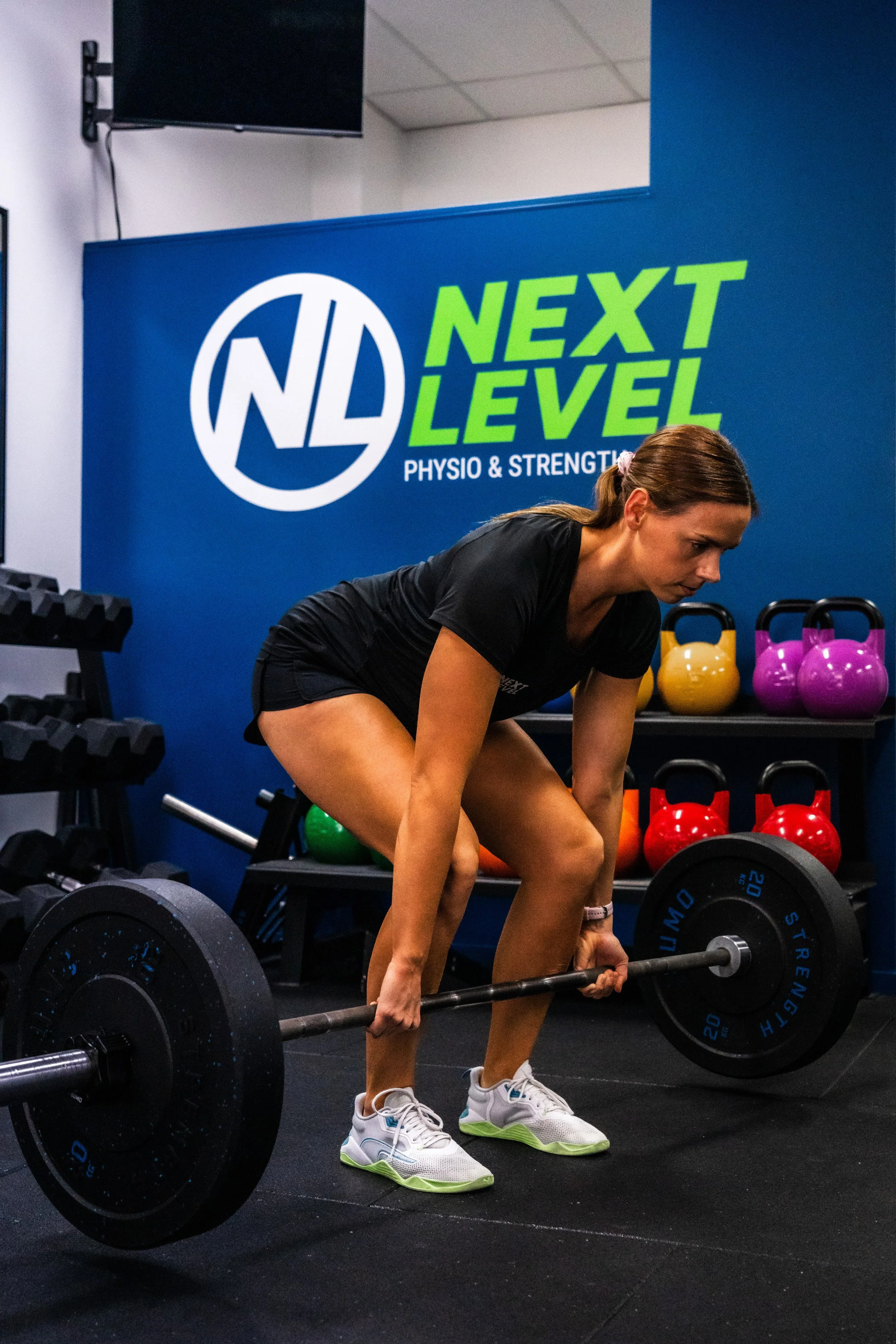 Physiotherapist guiding a client through strength-based gym injury rehabilitation in Varsity Lakes.