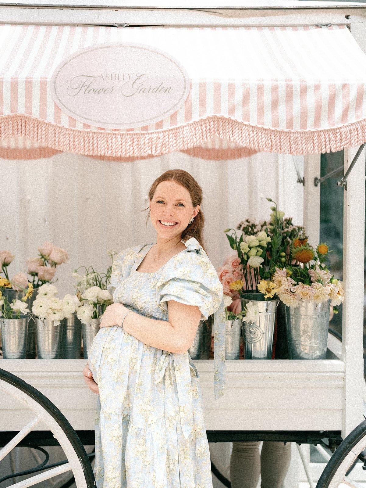 Mom to Be in Front of Flower Cart for Baby Shower with Growing Garden Theme in Houston, Texas