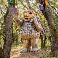 A giant wooden troll sculpture standing among oak trees at Filoli.